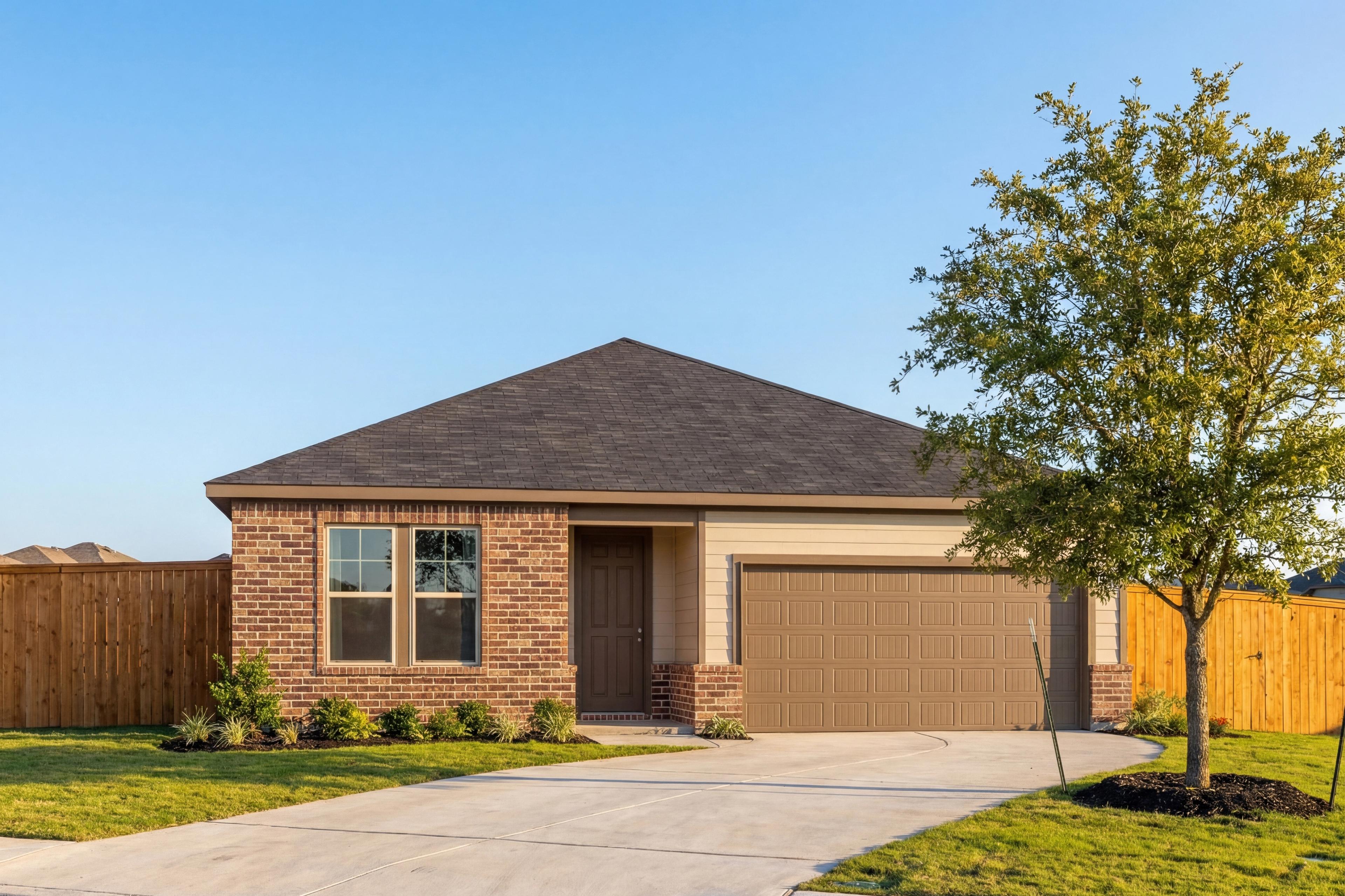 Modern single-story Daphne F home exterior by Davidson Homes: brick facade, tan 2-car garage, driveway, oak tree, and fenced yard in San Antonio