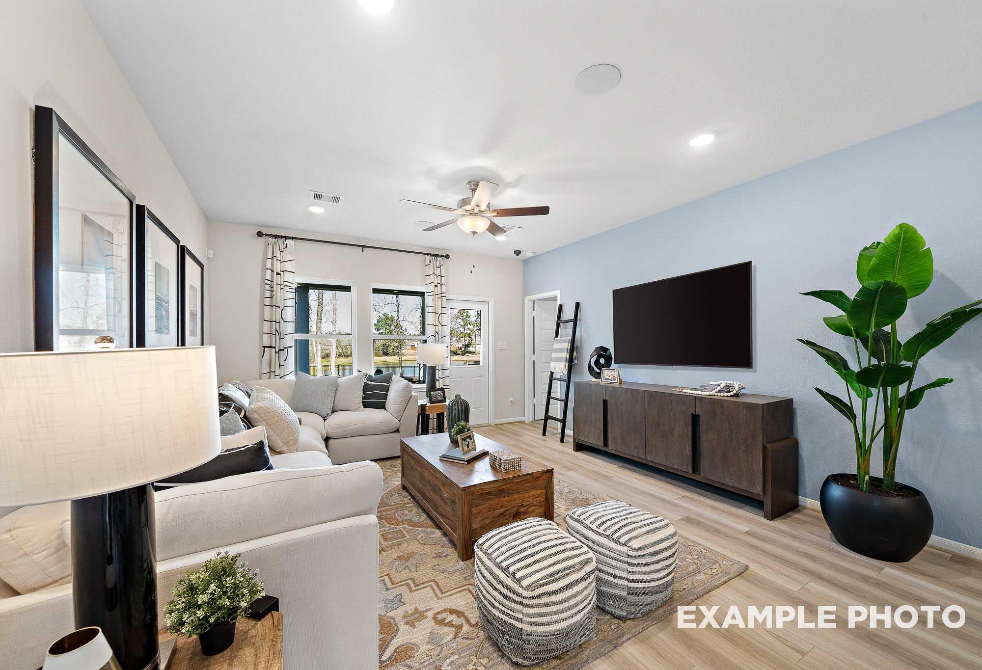 Open-concept living room in The San Marcos featuring a cozy sectional, modern media console, and light blue accent wall.