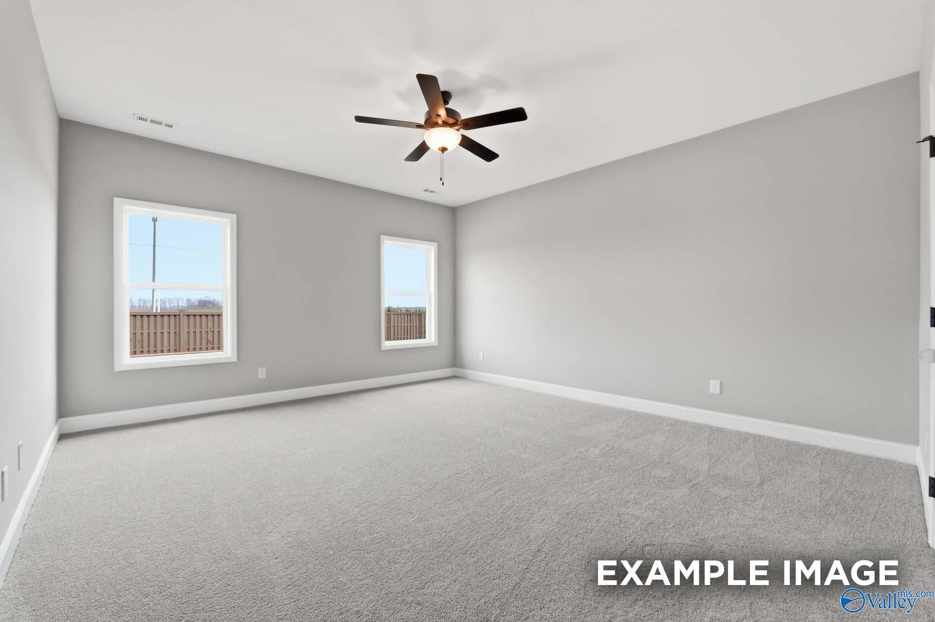 Spacious carpeted bedroom with ceiling fan and natural light in Davidson Homes Rockford C plan, Anderson Farm, Athens, Alabama