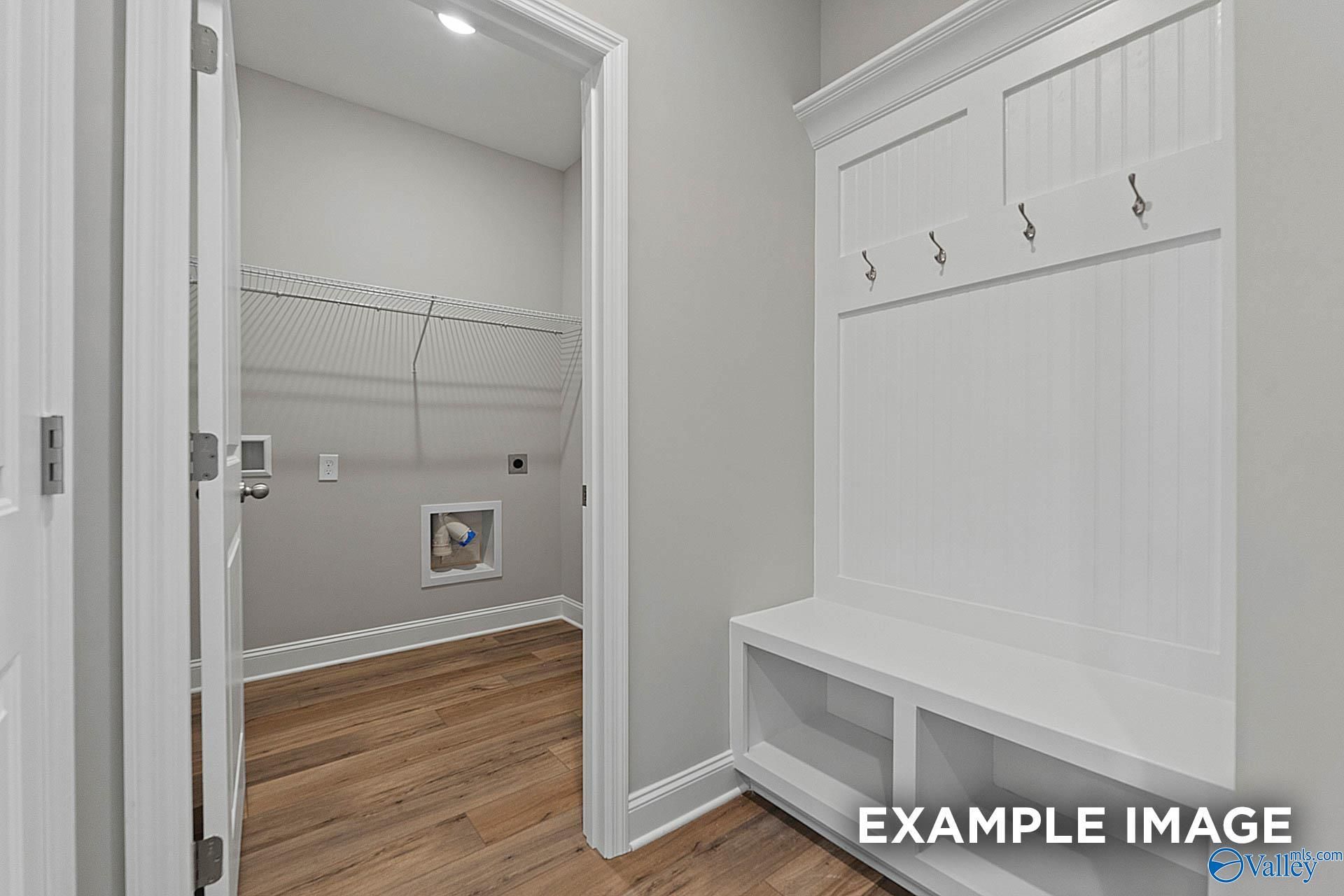 Functional mudroom with built-in bench, coat hooks, wire shelving, and laundry area in Davidson Homes The Franklin E, Hazel Green