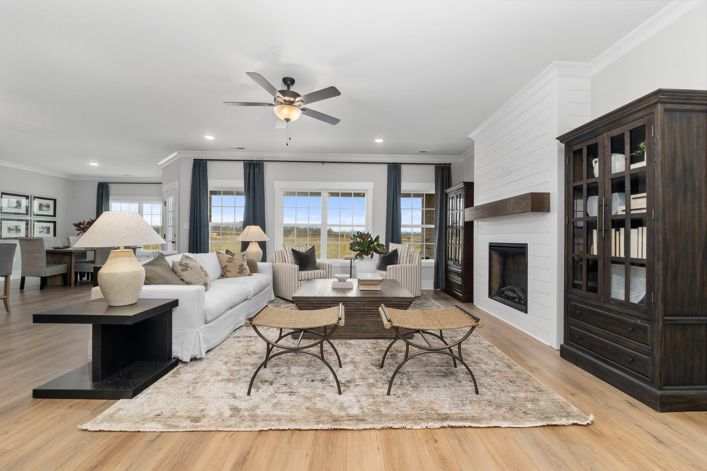 Cozy living room at Kendall Farms in Toney Alabama with shiplap walls, fireplace, built-in bookshelves, white sofa, and hardwood floors