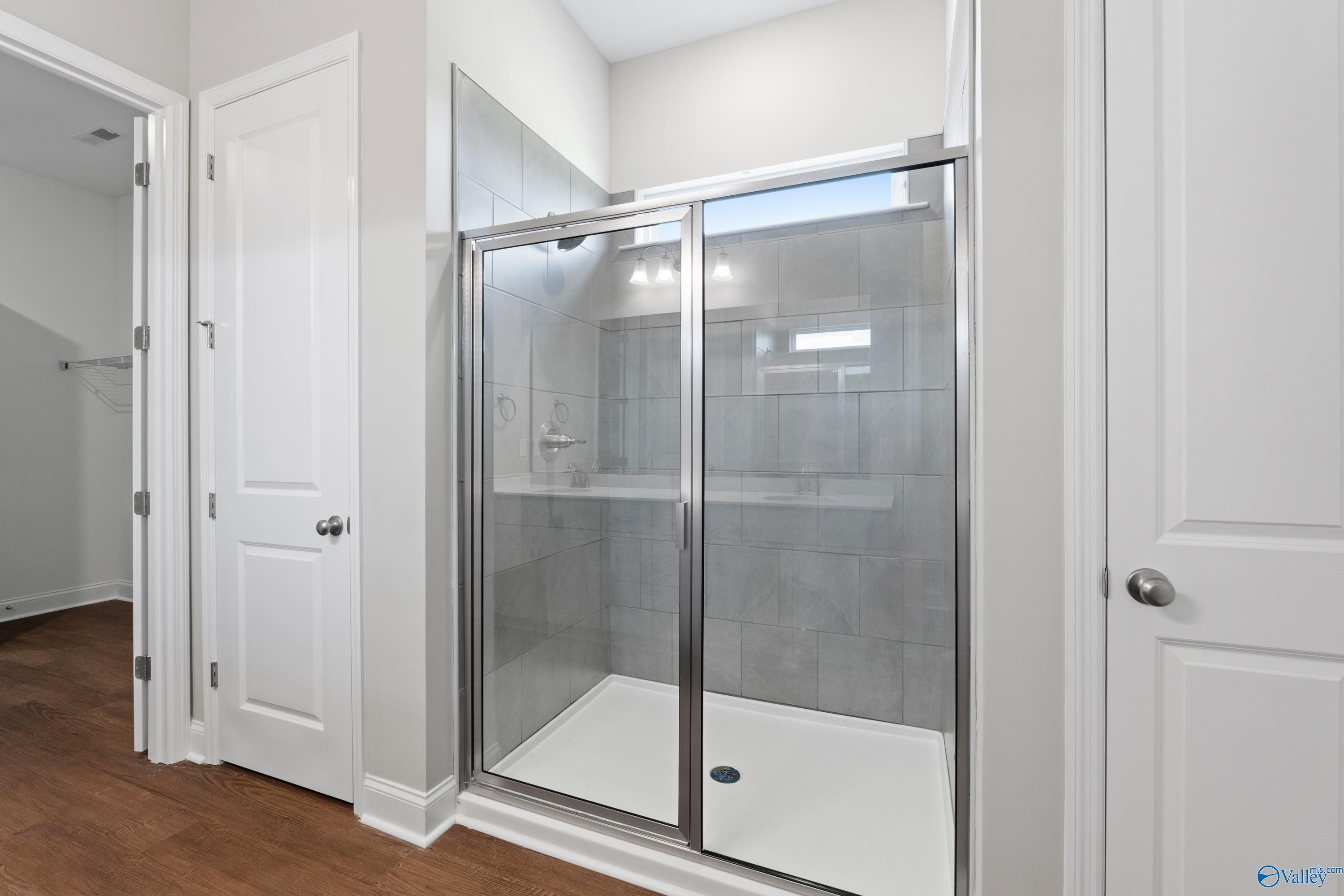 Modern glass shower with gray subway tiles and bench seat in master bath of The Arcadia B by Davidson Homes, Huntsville, AL
