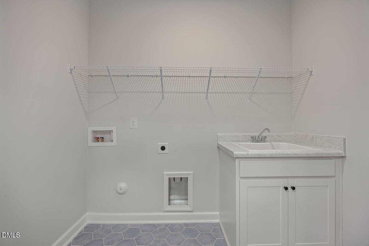 Laundry room with utility sink and wire shelving in The Birch II A floor plan at Montrose, Aberdeen, North Carolina.