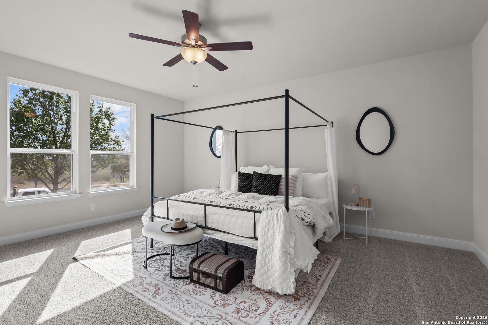 Elegant master bedroom with canopy bed, ceiling fan, and large windows in The Lanier H by Davidson Homes, Ladera, San Antonio