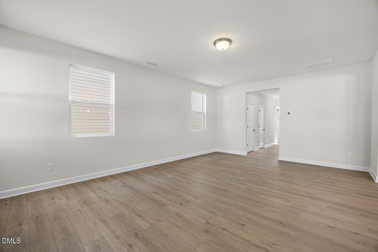 Bright, spacious living area with wood-look flooring in The Gavin A floor plan at Gregory Village in Lillington, NC.