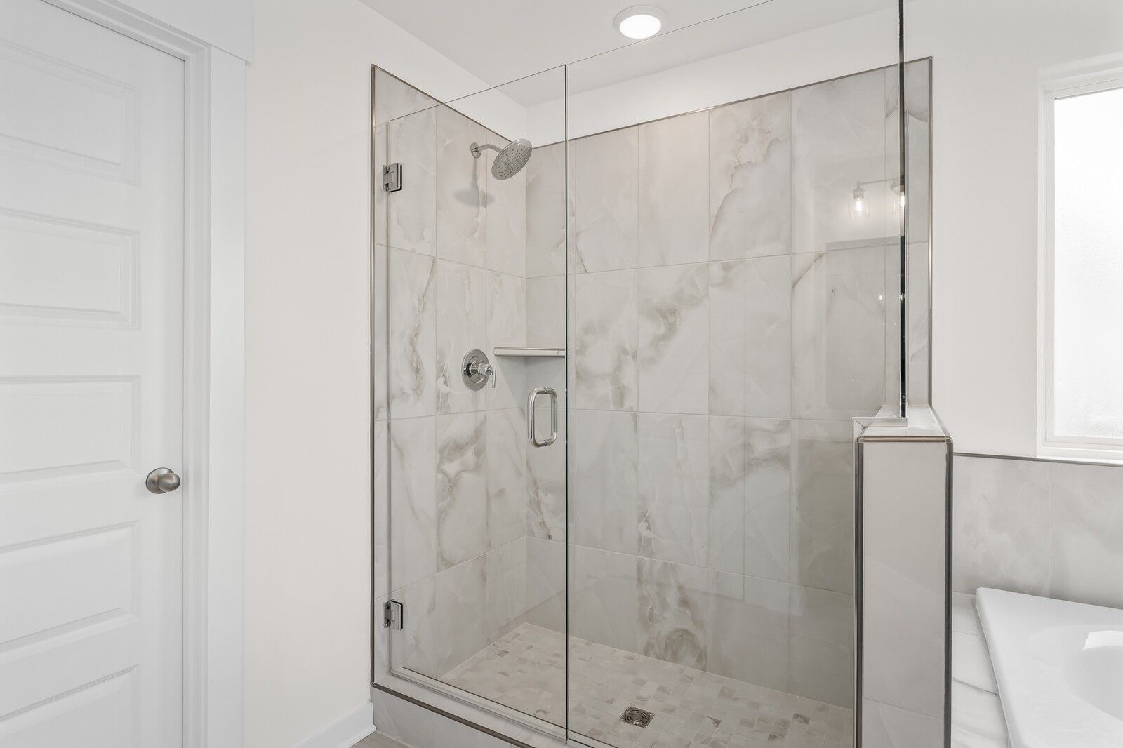 Modern walk-in tile shower with glass enclosure in The Henry C floor plan by Davidson Homes in Mt. Juliet, Tennessee.