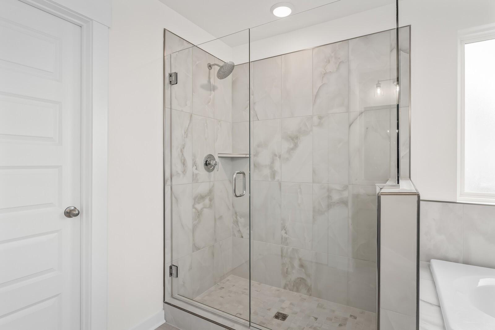 Modern walk-in tile shower with glass enclosure in The Henry C floor plan by Davidson Homes in Mt. Juliet, Tennessee.