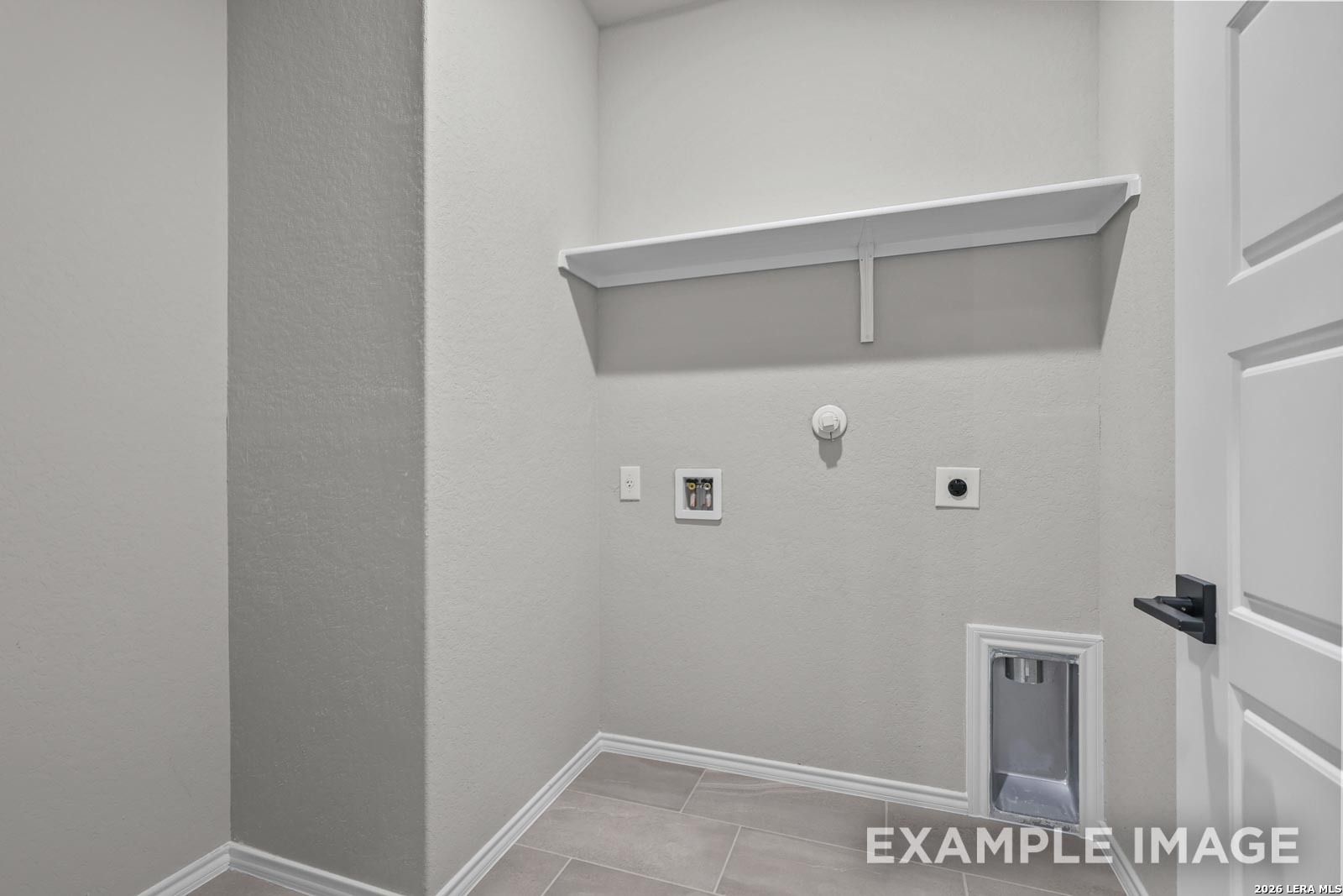 Laundry room with washer connections and overhead storage shelf in The Glenwood E floor plan at Royal Crest, San Antonio.