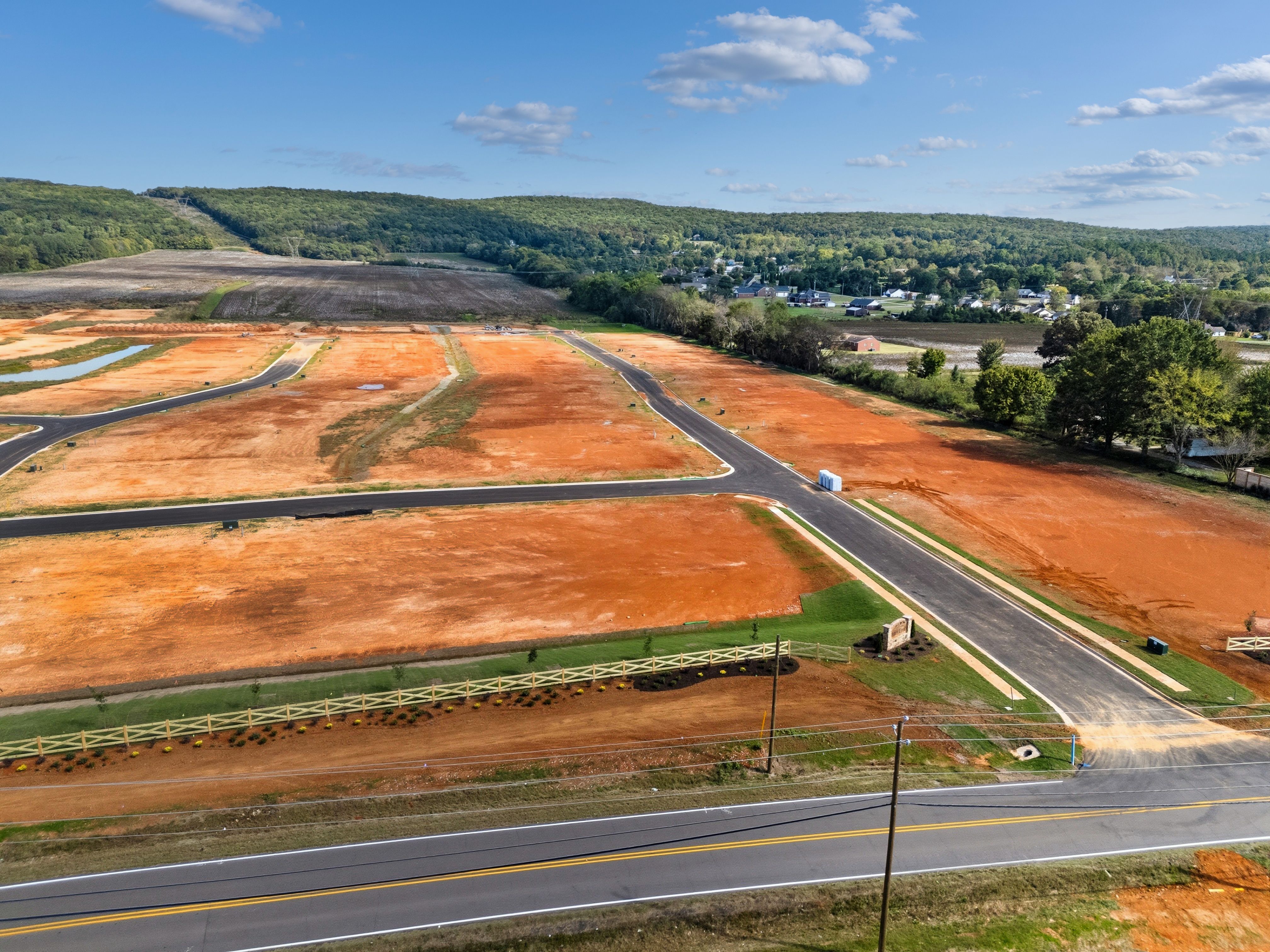 Aerial view of Berry Cove development in New Market Alabama featuring red dirt lots new roads and wooded hills