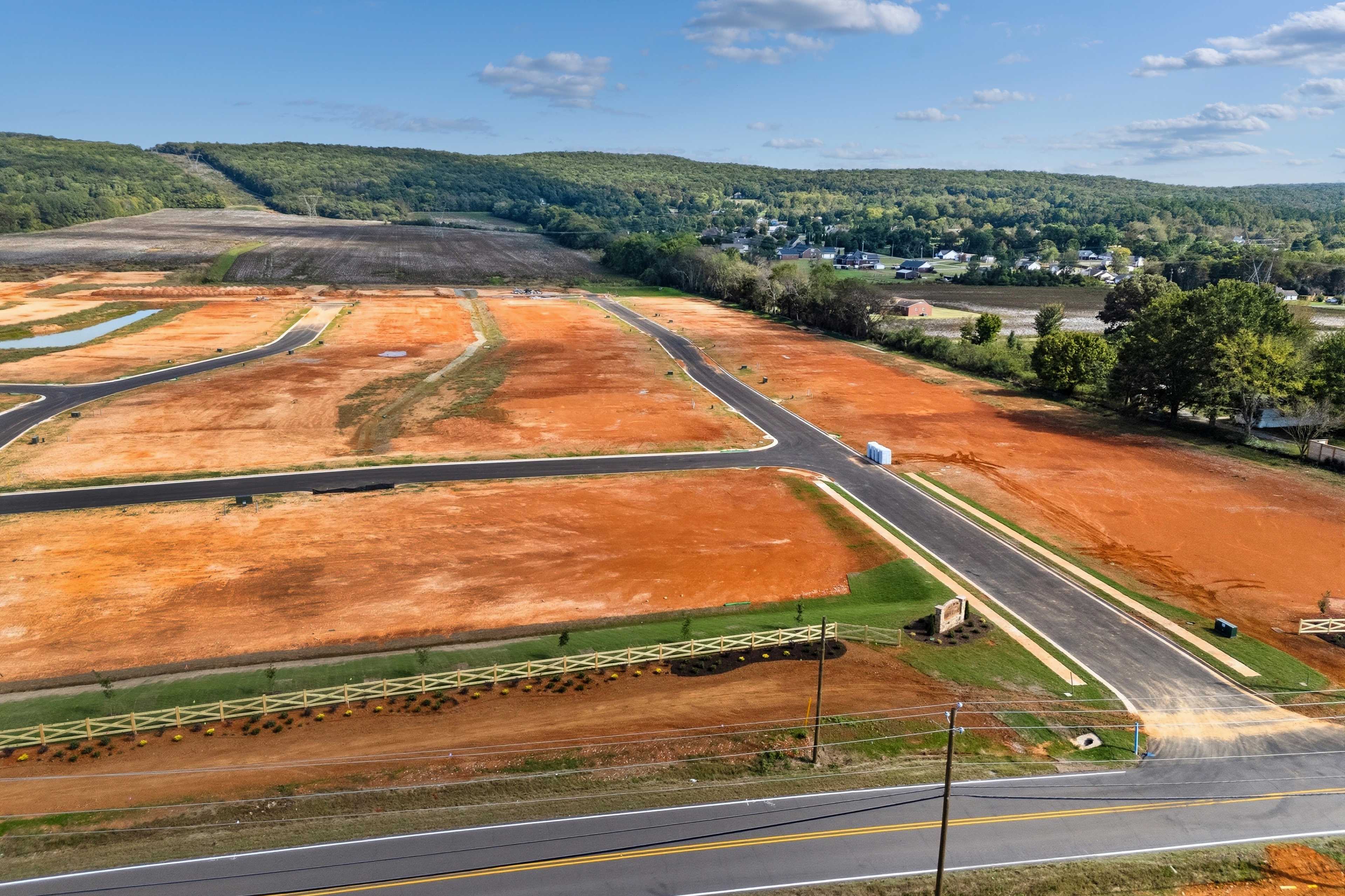 Aerial view of Berry Cove development in New Market Alabama featuring red dirt lots new roads and wooded hills