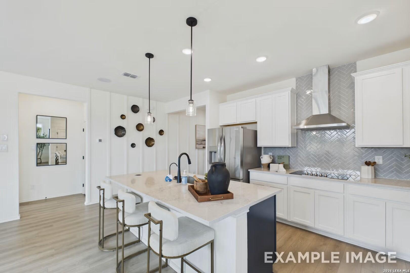 Modern kitchen with island, white cabinetry, and herringbone backsplash in The Laurel I floor plan, Rayburn Valley home.