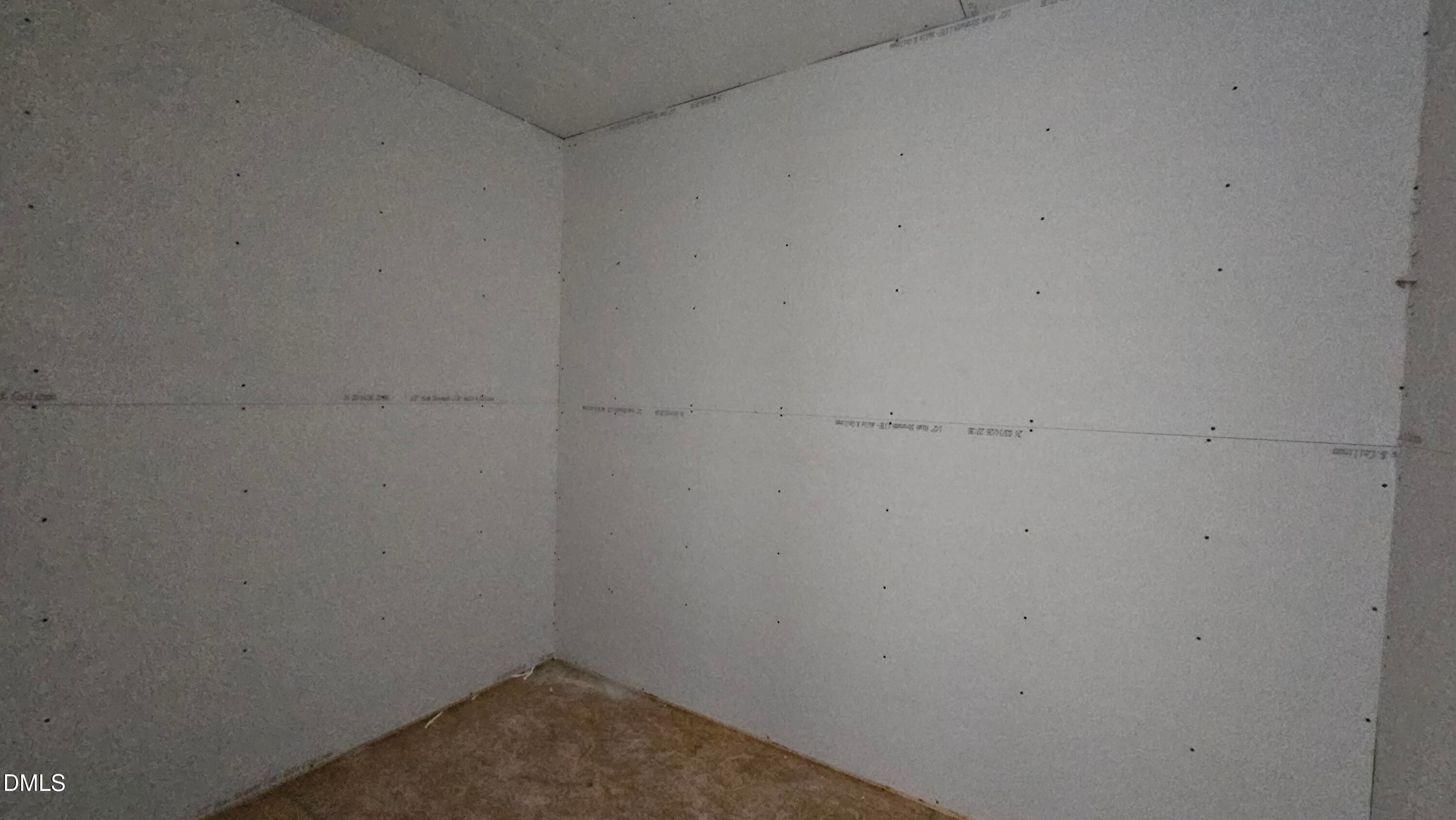 Unfinished bedroom with drywall installation in The Graham Interior floor plan at Springvale, Fuquay-Varina, North Carolina.