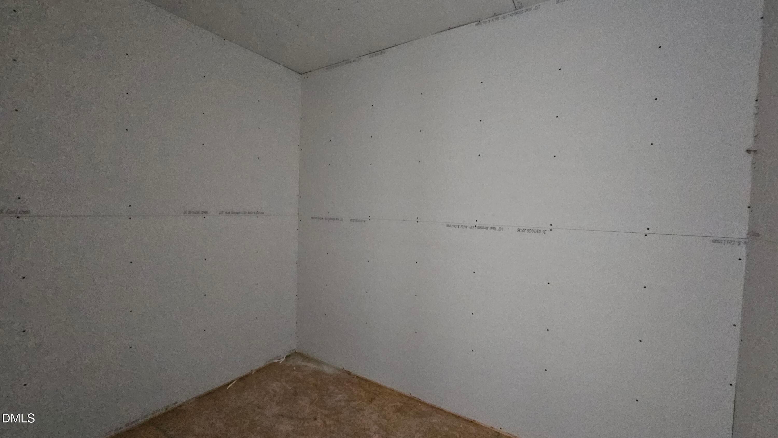 Unfinished bedroom with drywall installation in The Graham Interior floor plan at Springvale, Fuquay-Varina, North Carolina.
