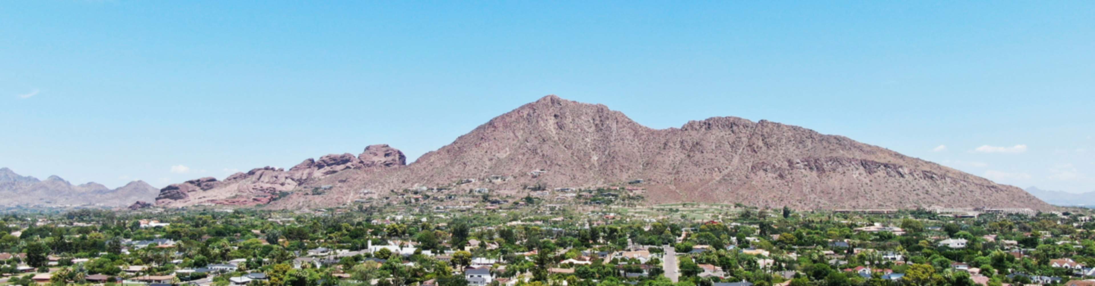Aerial view of new home community in Arizona with suburban neighborhoods and desert mountains