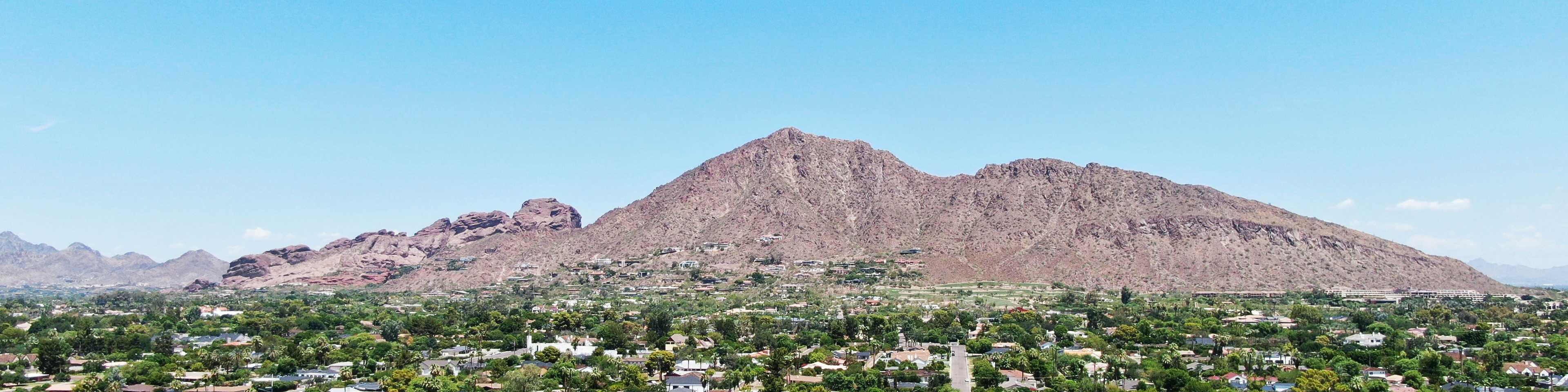 Aerial view of new home community in Arizona with suburban neighborhoods and desert mountains