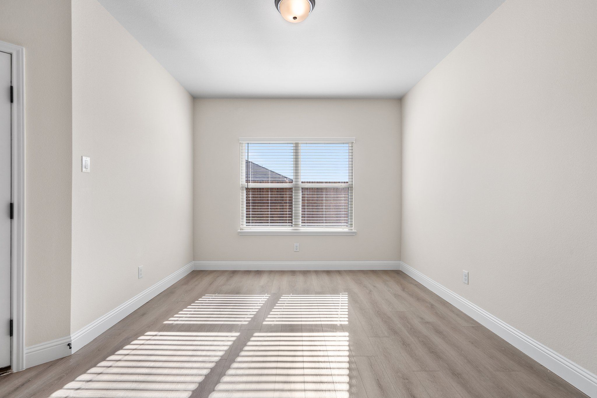 Bright, spacious bedroom in The Holly F floor plan by Davidson Homes featuring light wood flooring and neutral walls.