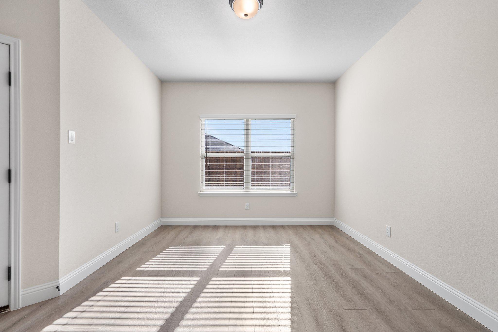 Bright, spacious bedroom in The Holly F floor plan by Davidson Homes featuring light wood flooring and neutral walls.