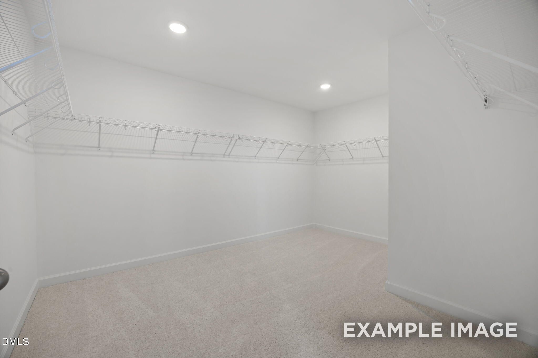 Spacious walk-in closet with wire shelving and carpet in The Beech floor plan by Davidson Homes, Wendell Ridge, North Carolina