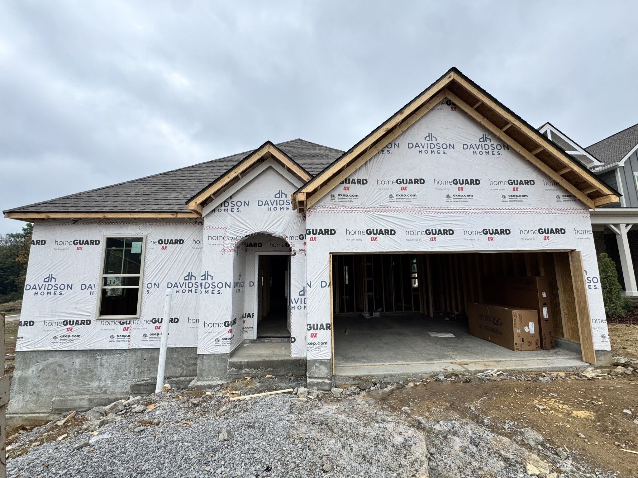 New construction single-story home under construction with 2-car garage by Davidson Homes at Woods Crossing in Gallatin, Tennessee