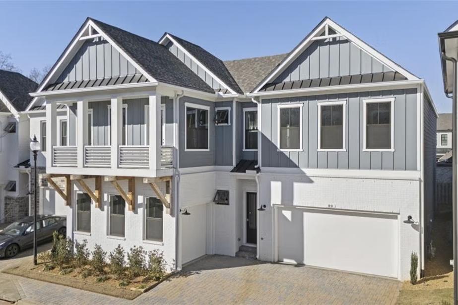 Modern Craftsman-style home exterior at The Village at Towne Lake in Woodstock, Georgia with balcony, garage, and landscaping