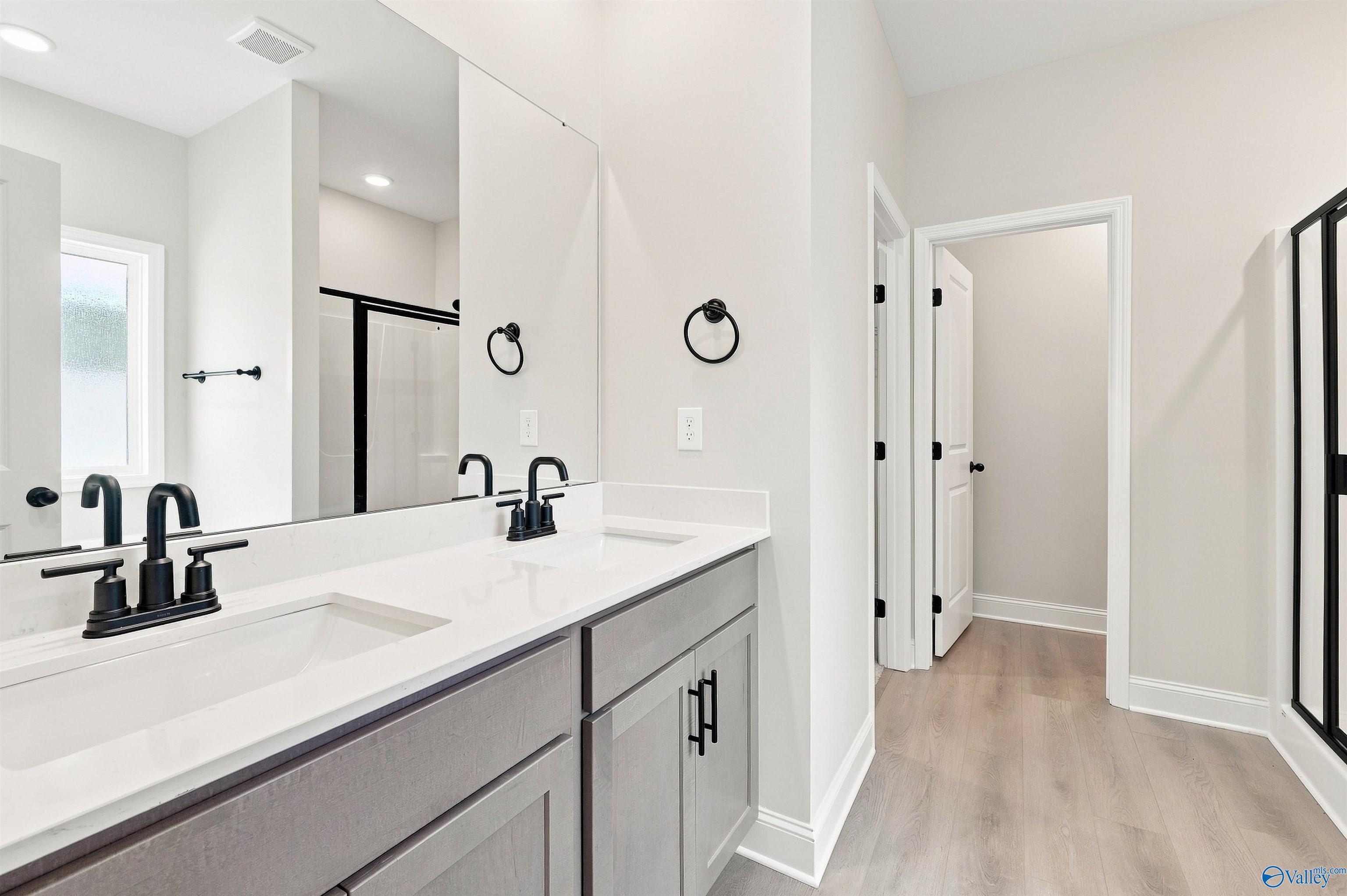Modern bathroom with dual vanity, quartz countertops, and matte black fixtures in The Daphne plan at Spragins Cove, Huntsville.