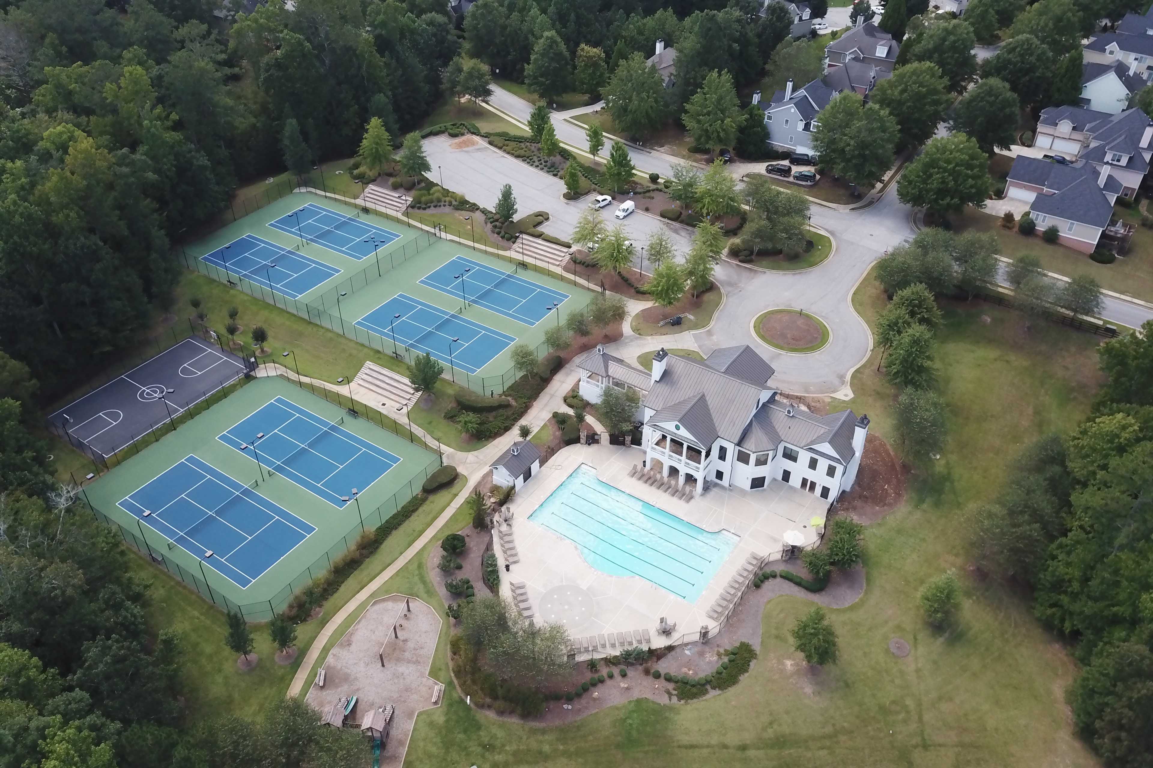 Resort-style pool, tennis courts, basketball court and clubhouse at Riverwood community in Dallas Georgia by Davidson Homes