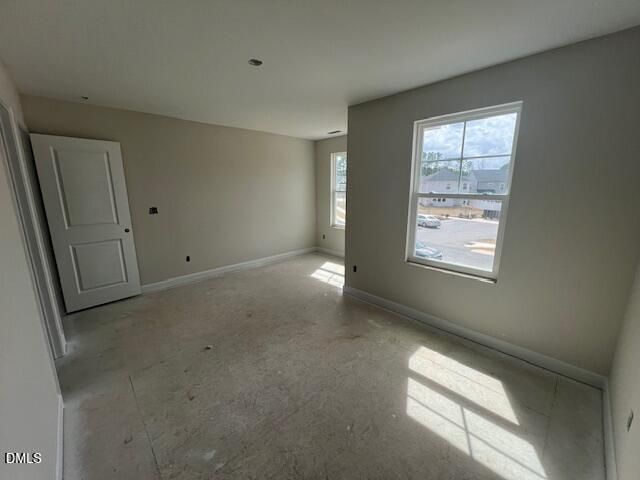 Bright empty bedroom with neutral walls, large windows, and natural light in Davidson Homes The Preston A, Lillington, NC
