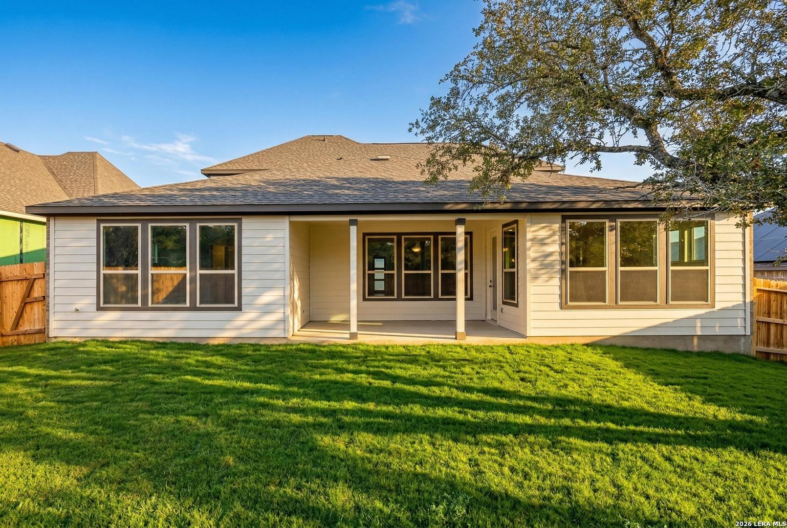 Covered back patio and spacious grassy backyard of The Belmont G floor plan at The Reserve at Potranco Oaks in Castroville.