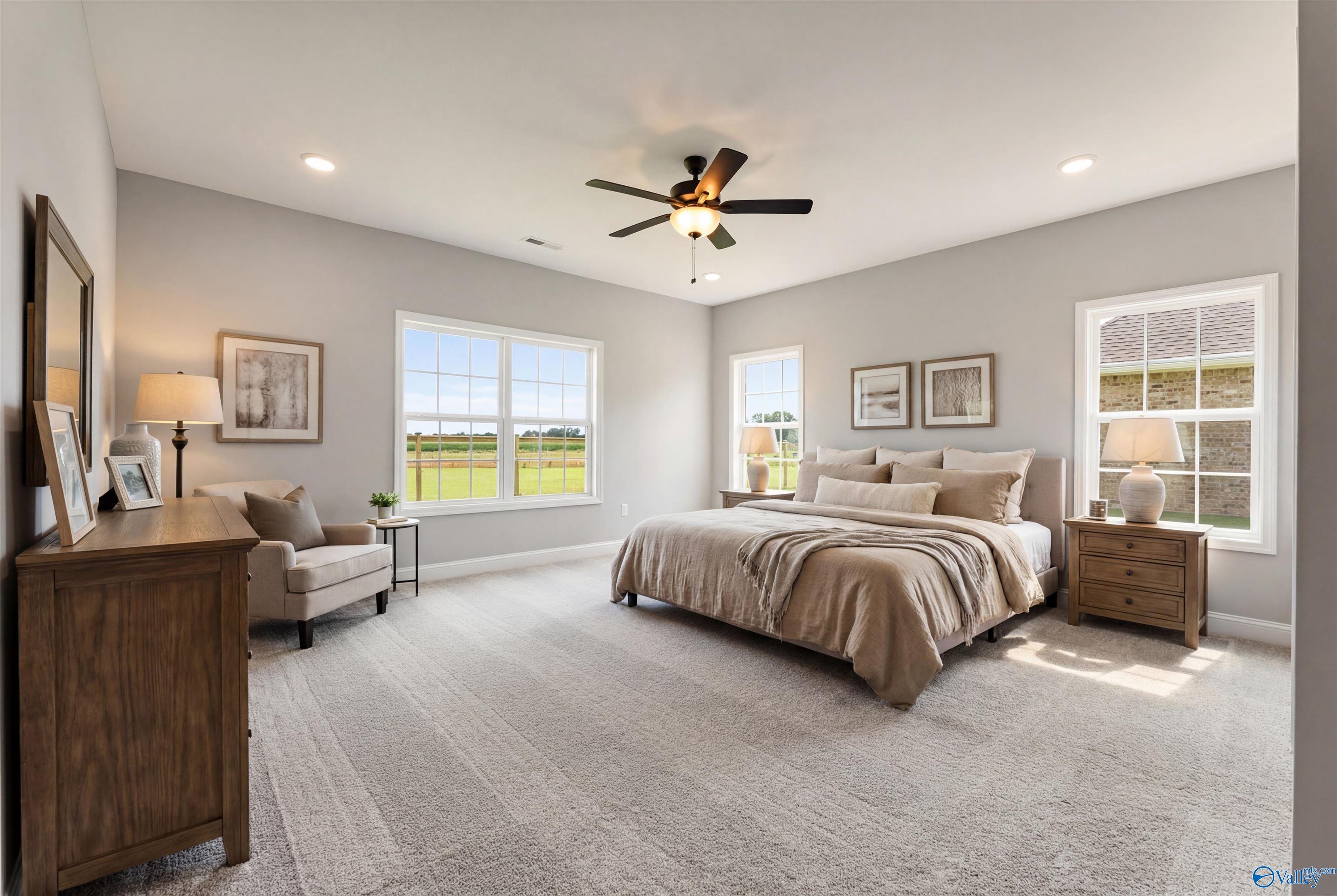 Serene master bedroom with large windows overlooking fields, ceiling fan, king bed in Davidson Homes The Finleigh, Toney, AL