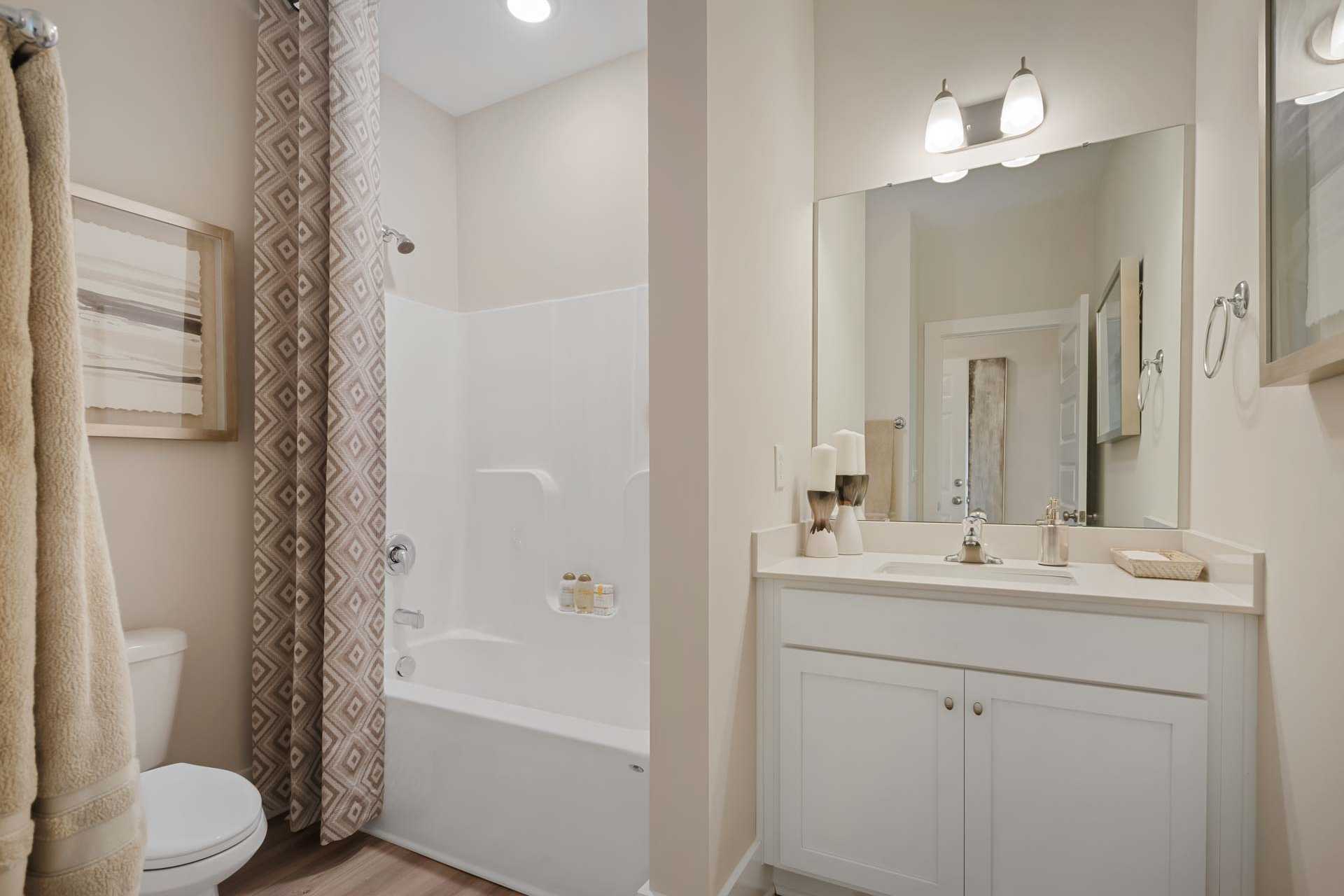 Modern bathroom at Flint Meadows in New Market AL with bathtub shower combo, double vanity, and neutral tones