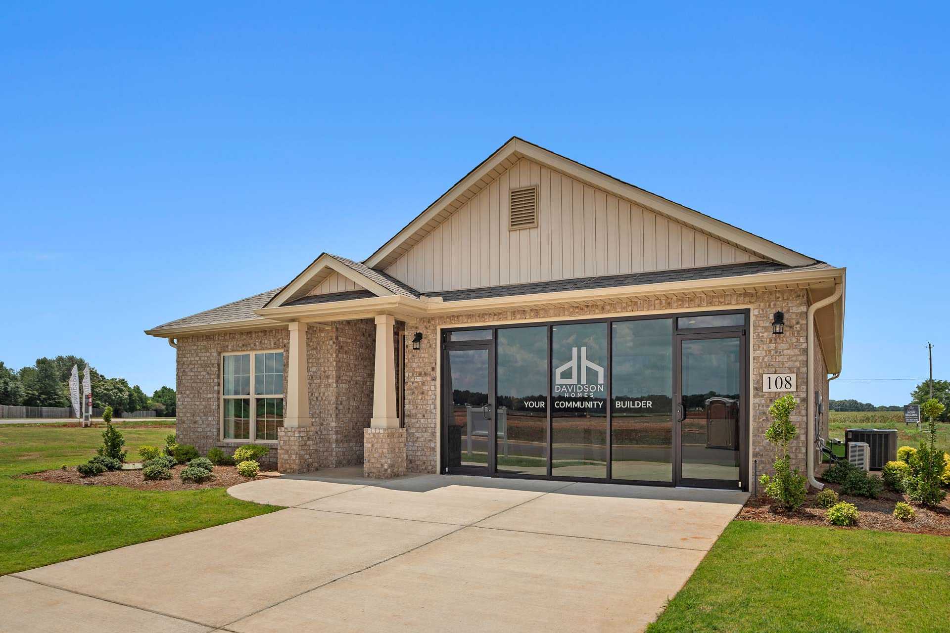 Davidson Homes model home exterior at Heritage Lakes in New Market Alabama with brick base siding and glass entry