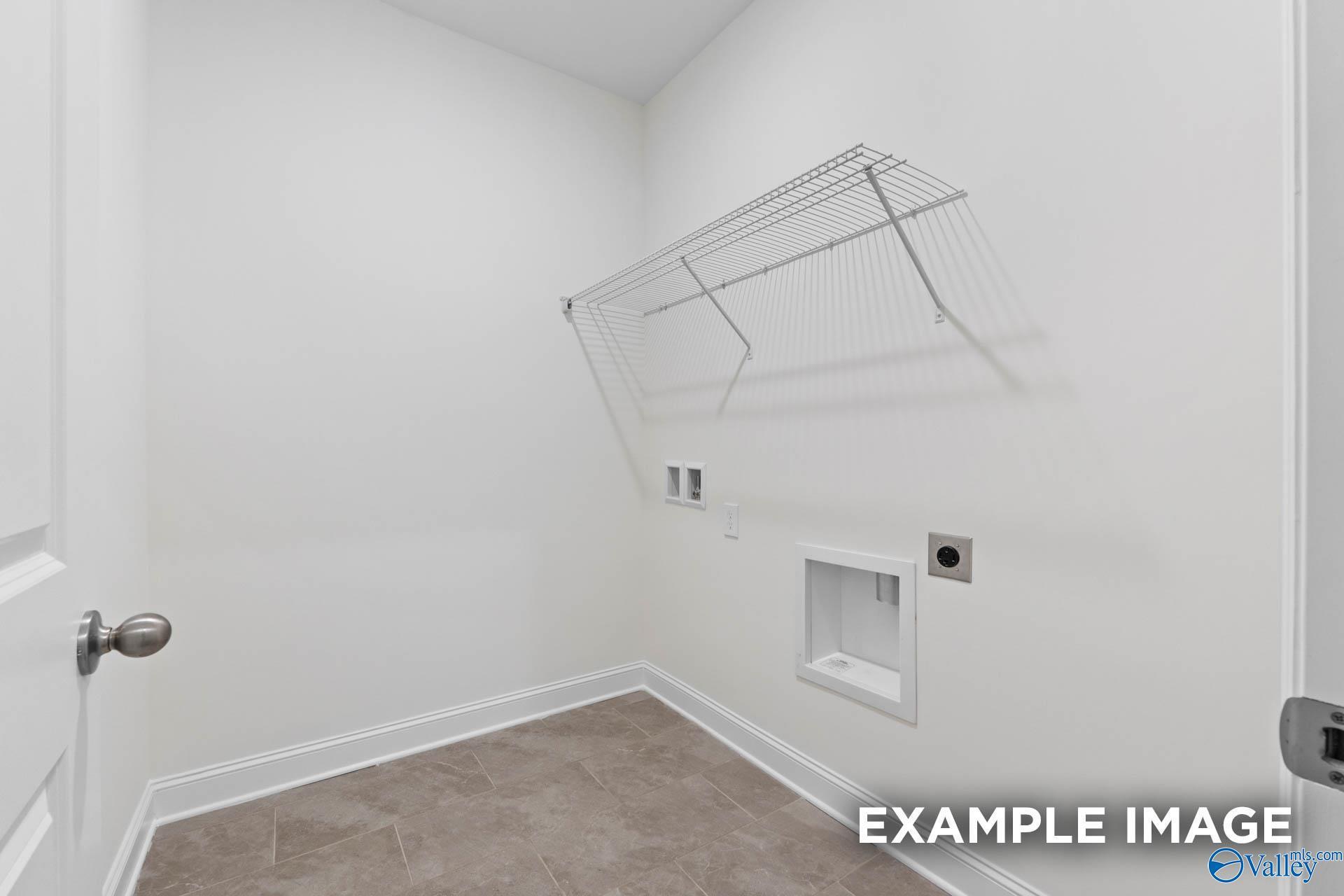 Bright laundry room with wire shelving, utility sink, and washer-dryer hookups in Davidson Homes The Rockford B, Athens Alabama
