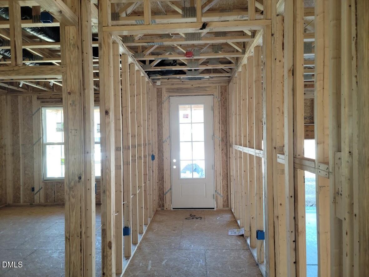 Interior wooden framing with glass-paneled door and windows in unfinished 5-bedroom Ashport G home by Davidson Homes, Angier, NC