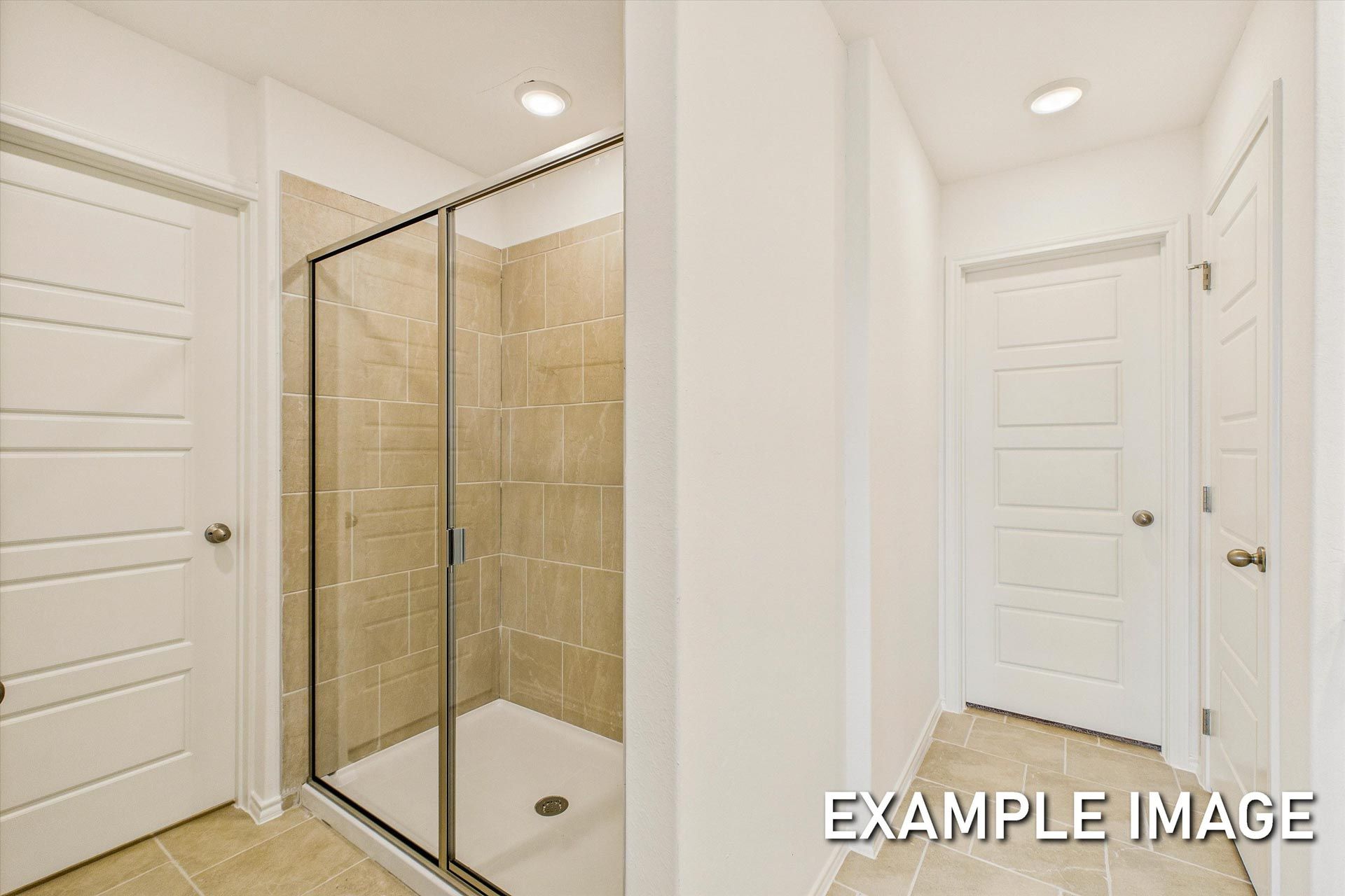 Modern master bathroom in The Trinity B showcasing walk-in shower with glass enclosure and beige tile walls