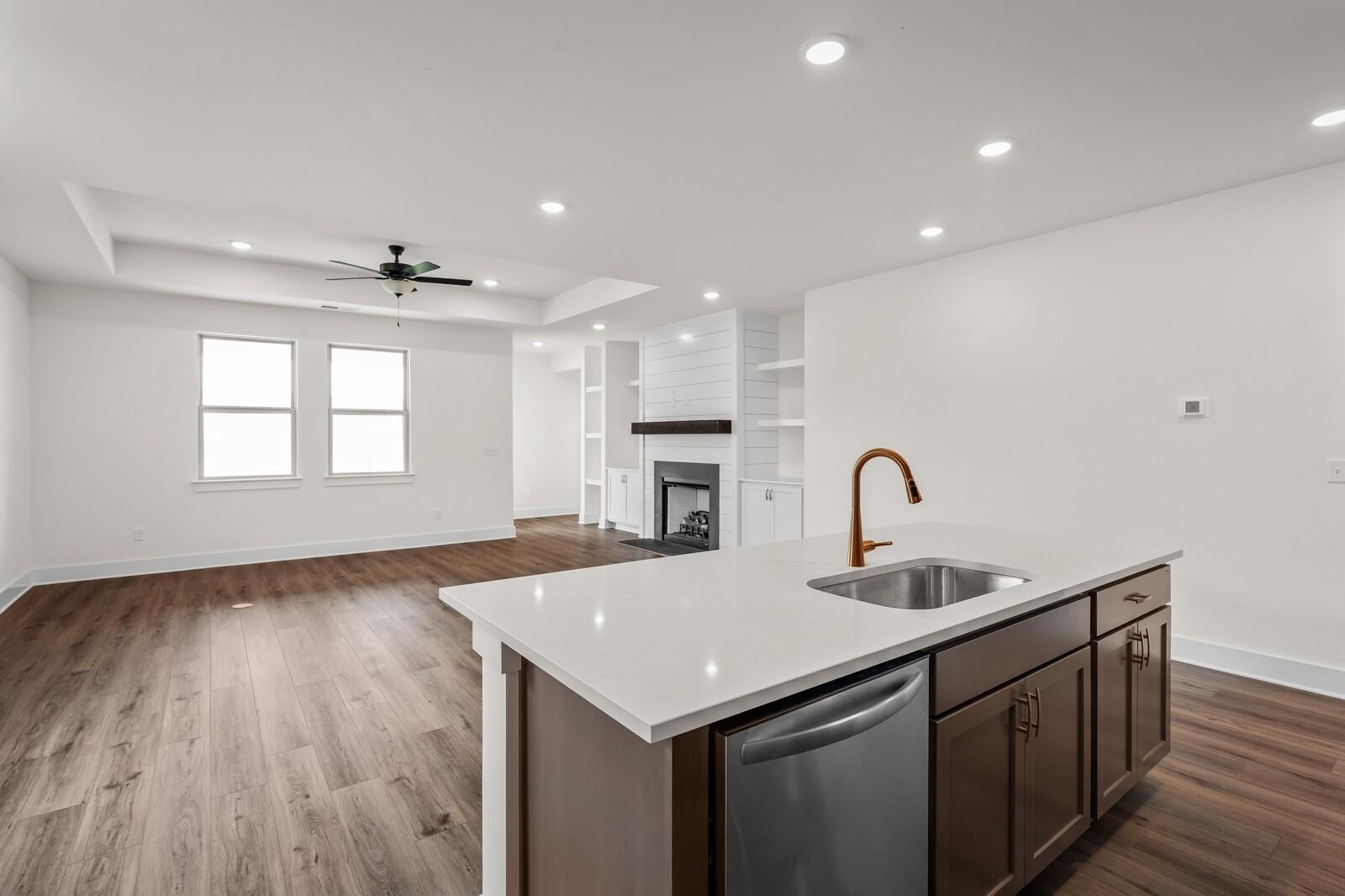 Open-concept kitchen and living area with shiplap fireplace in The Prairie C floor plan at Woods Crossing, Gallatin, TN.