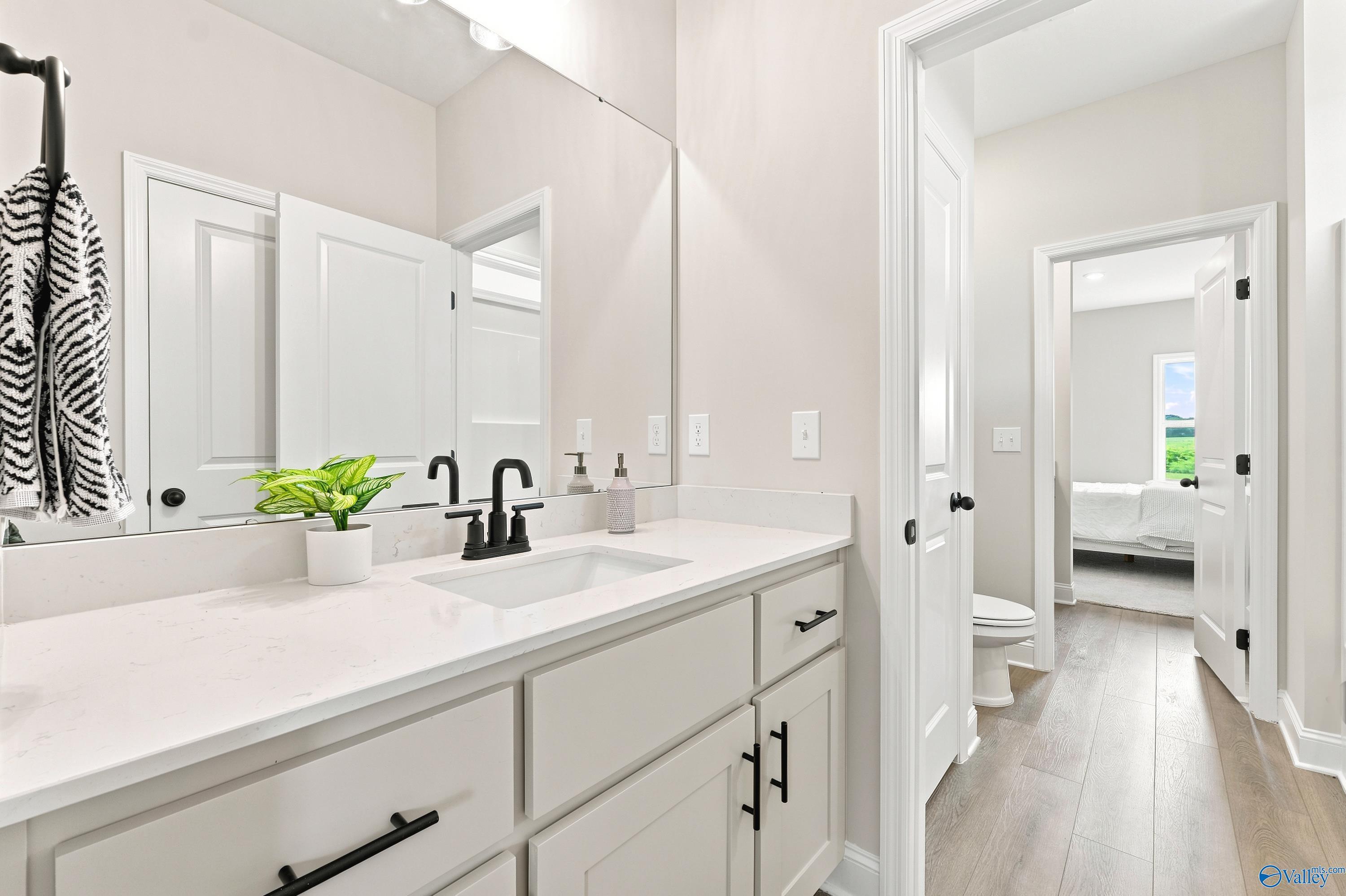 Modern bathroom vanity with quartz countertops and black fixtures in The Finleigh floor plan at Riverton Preserve, Huntsville