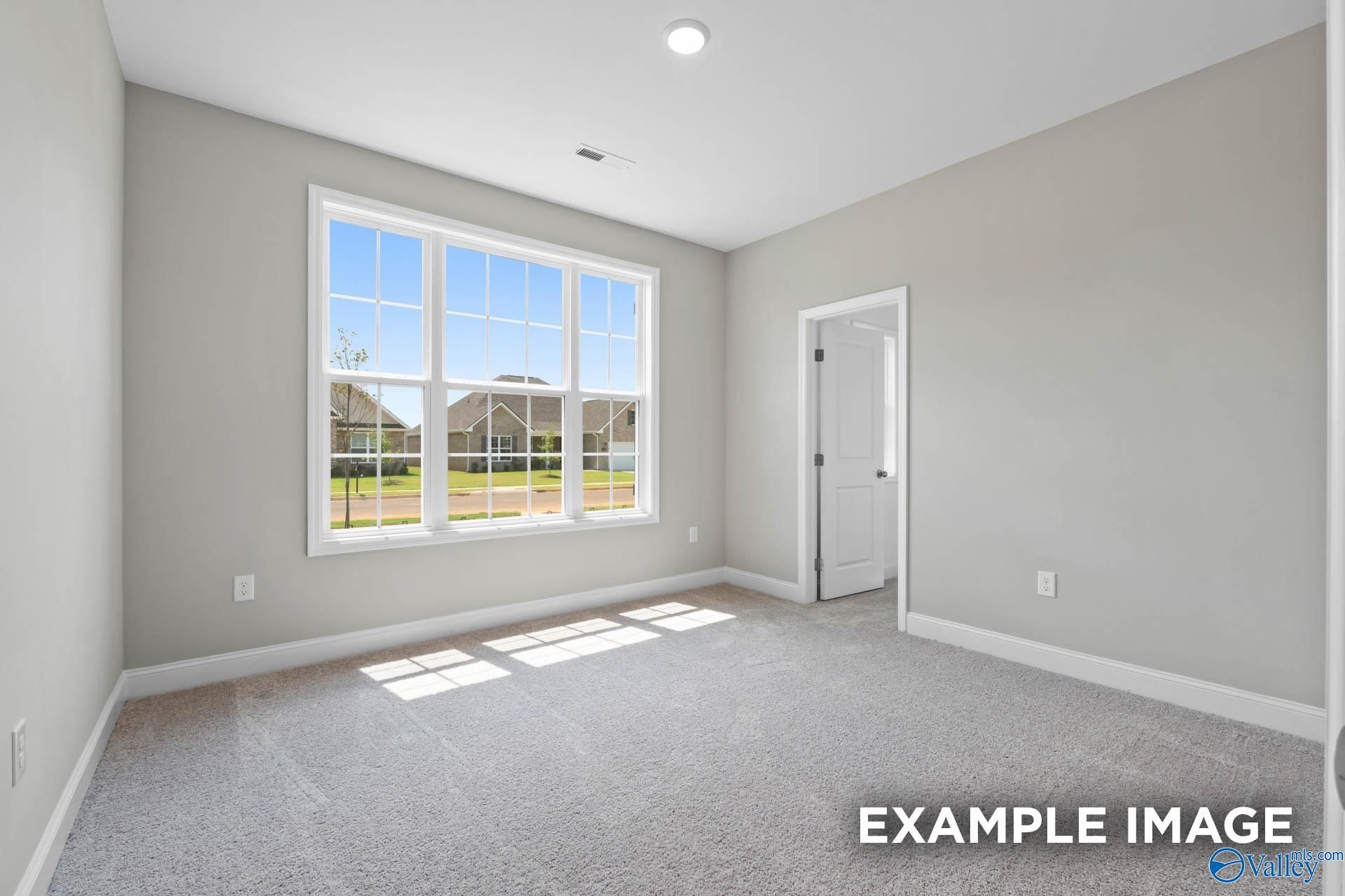 Sunny secondary bedroom with large window overlooking neighborhood in Davidson Homes The Montgomery, Pikes Ridge, Meridianville, Alabama