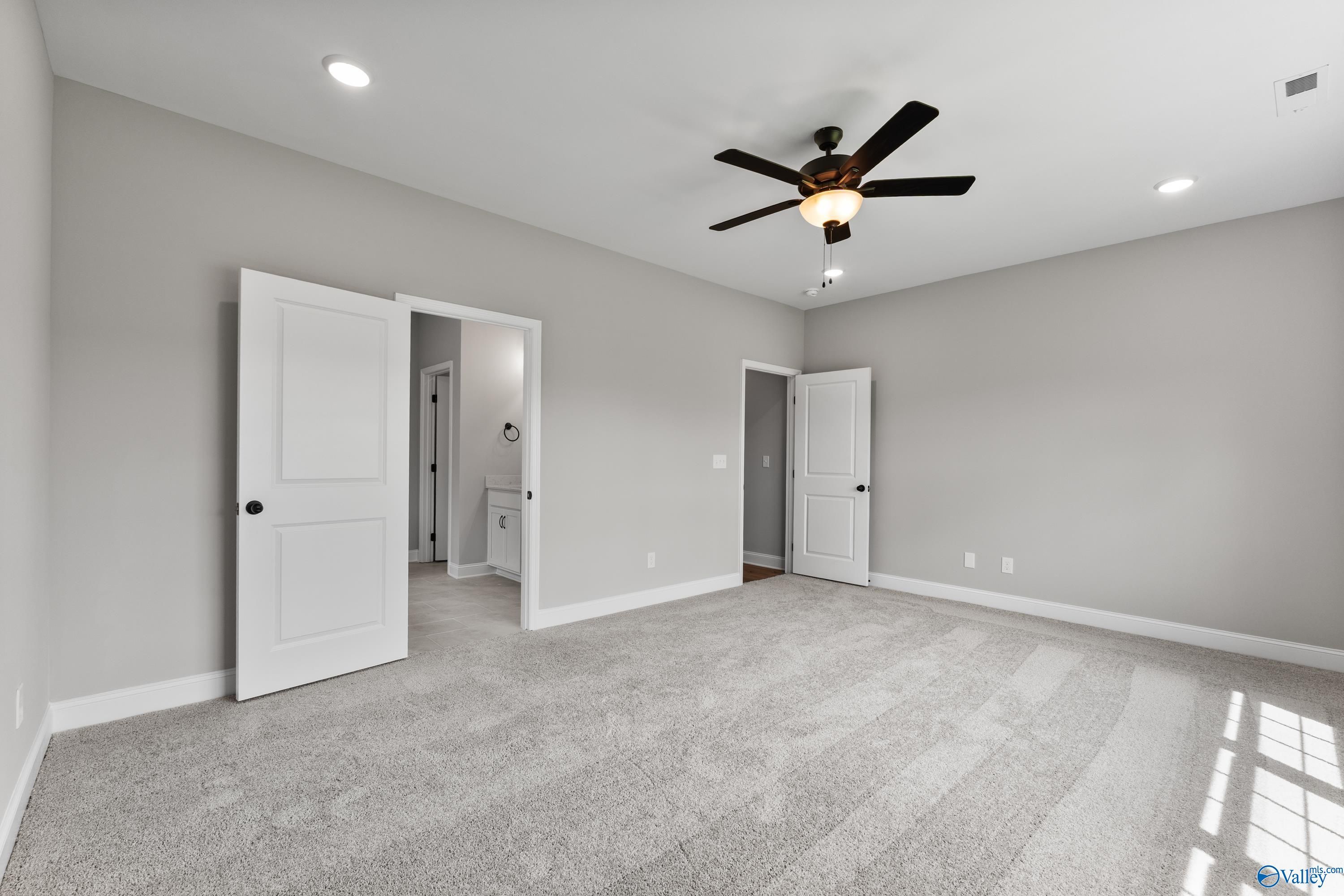 Spacious secondary bedroom with attached bath, gray walls, plush carpet, and ceiling fan in Davidson Homes Montgomery B With Bonus, Toney, AL