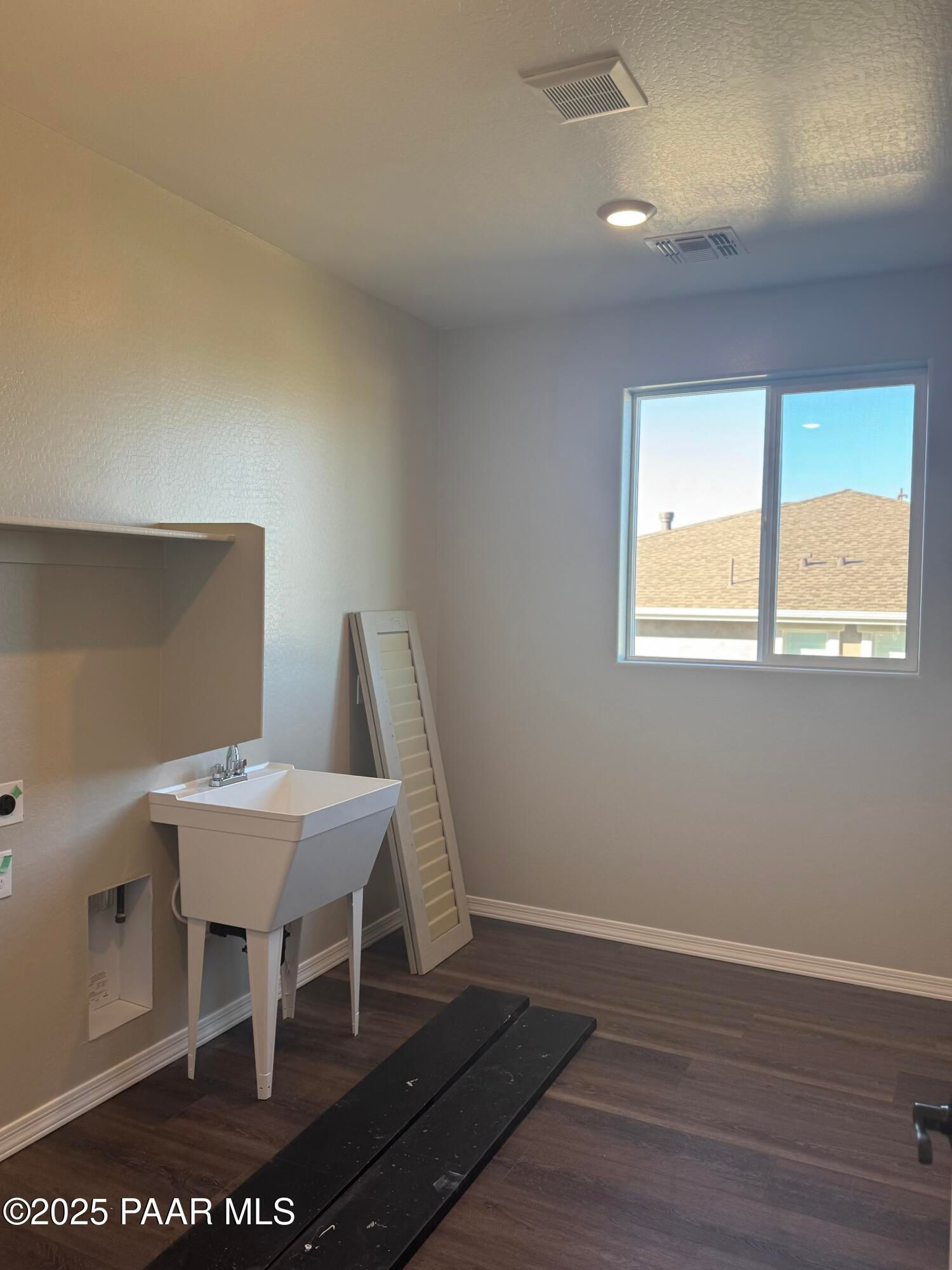 Spacious laundry room with utility sink, washer hookups and large window in Davidson Homes The Monarch E, Prescott, AZ