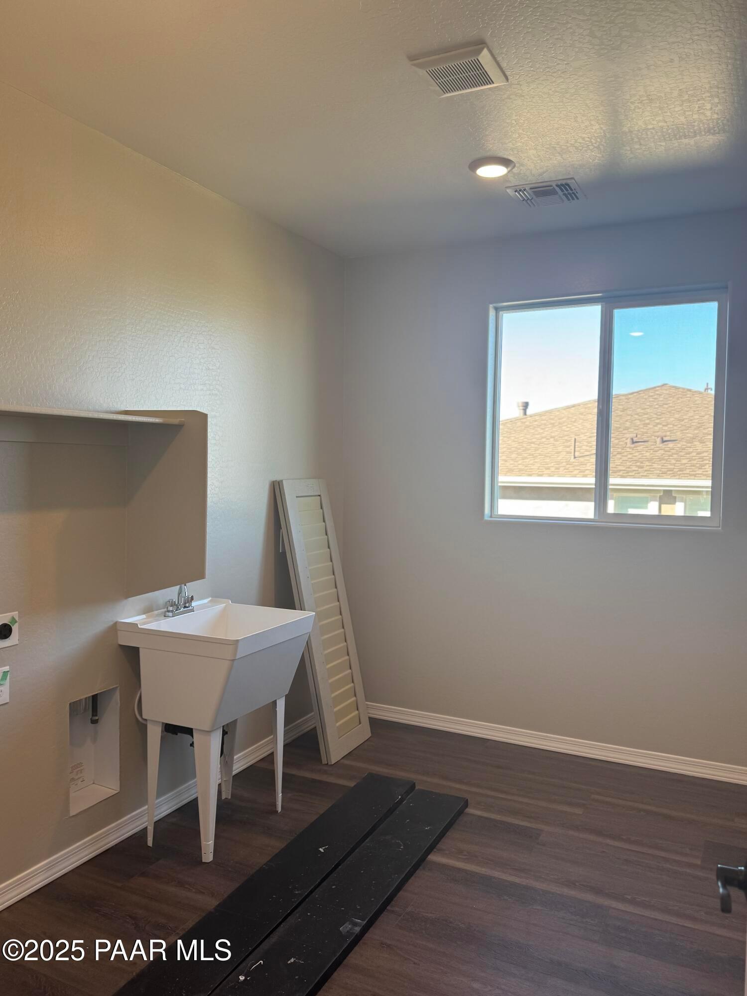 Spacious laundry room with utility sink, washer hookups and large window in Davidson Homes The Monarch E, Prescott, AZ