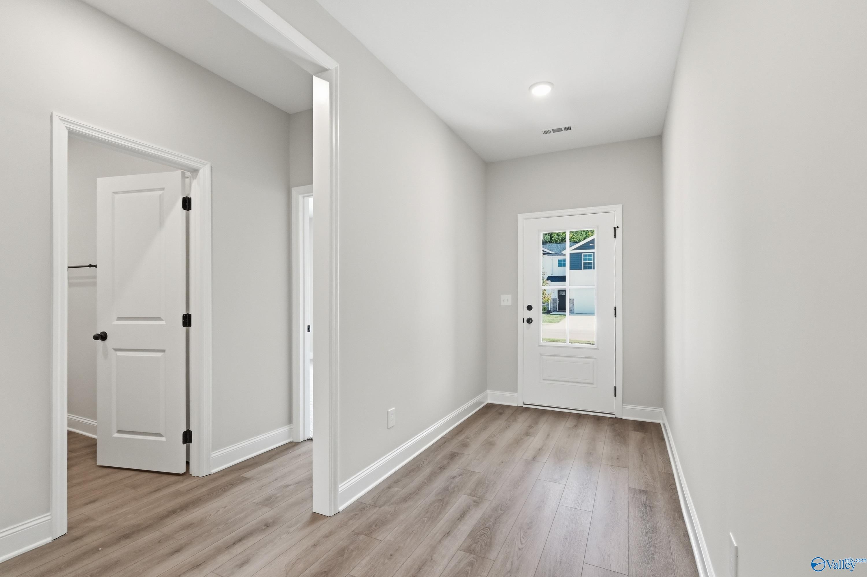 Bright entryway with wood-style flooring in The Daphne F floor plan by Davidson Homes in Forest Glen, Hazel Green, AL.