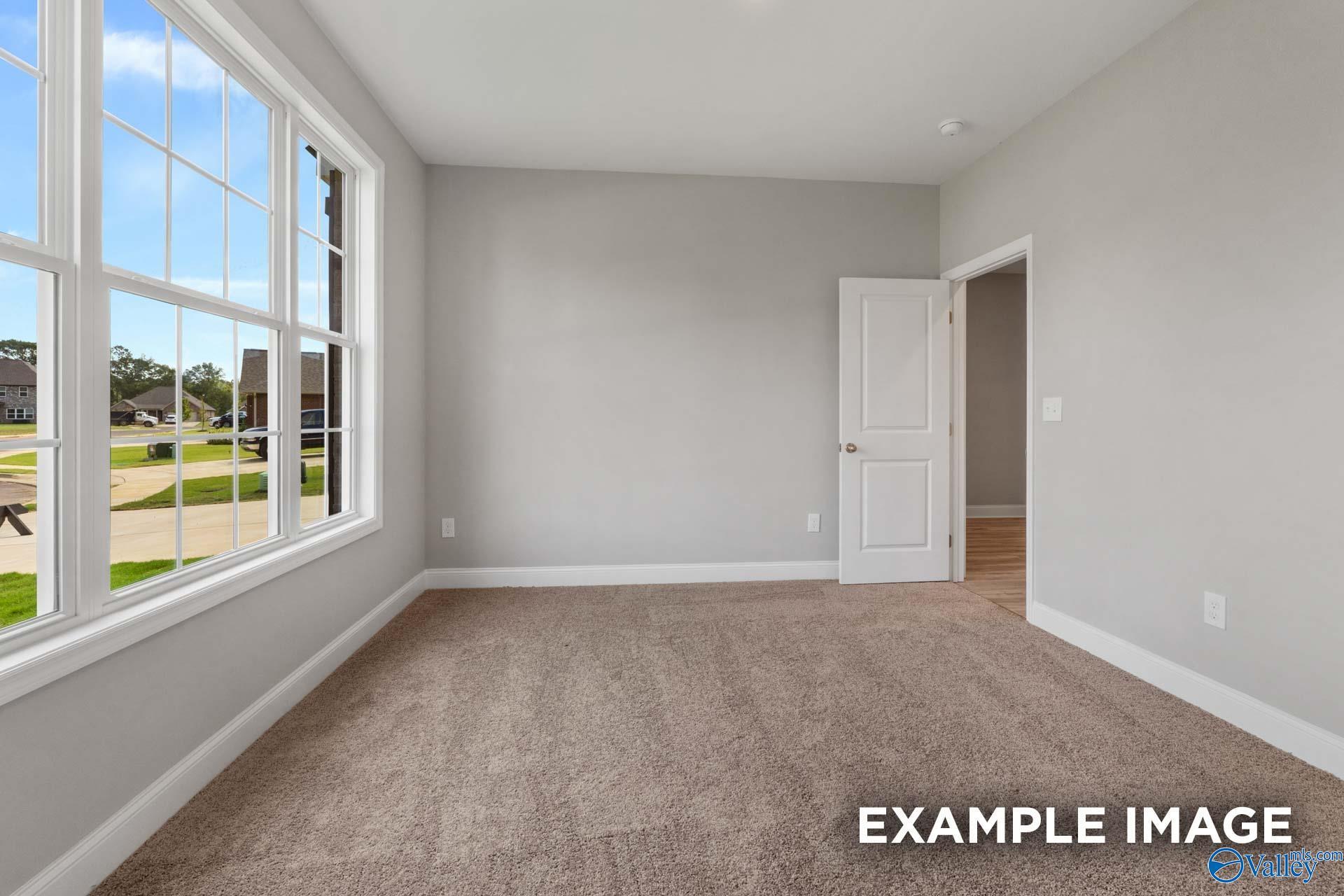 Bright secondary bedroom with gray walls, beige carpet, and large windows overlooking Toney neighborhood in Montgomery B home