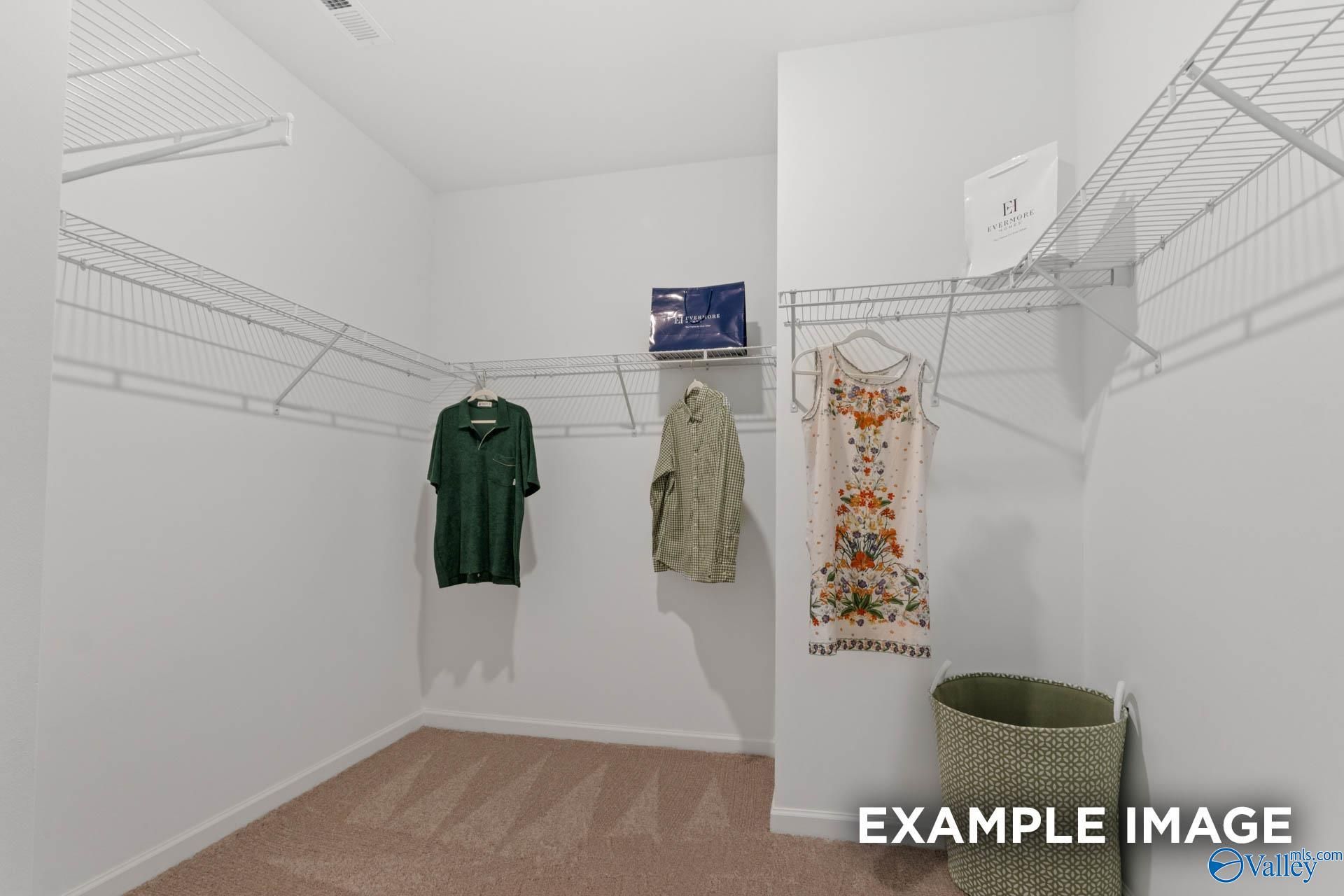 Spacious walk-in closet with wire shelving, hanging clothes and storage in Davidson Homes The Stella, Madison AL