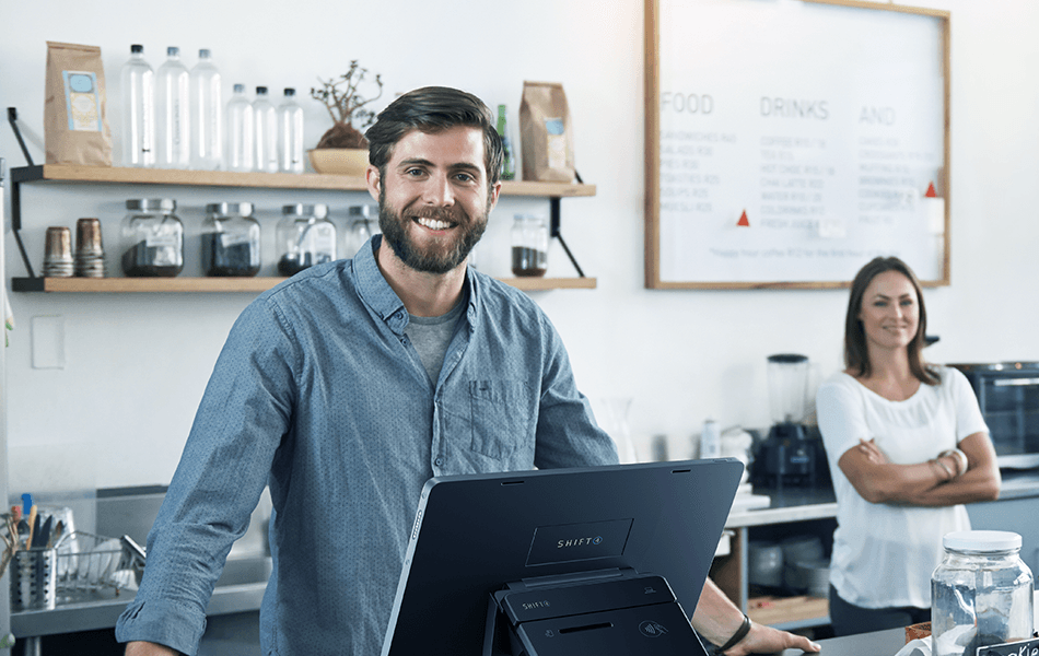 Smiling man behind a SkyTab POS system next to a smiling woman, both behind a counter - POS hardware - SkyTab