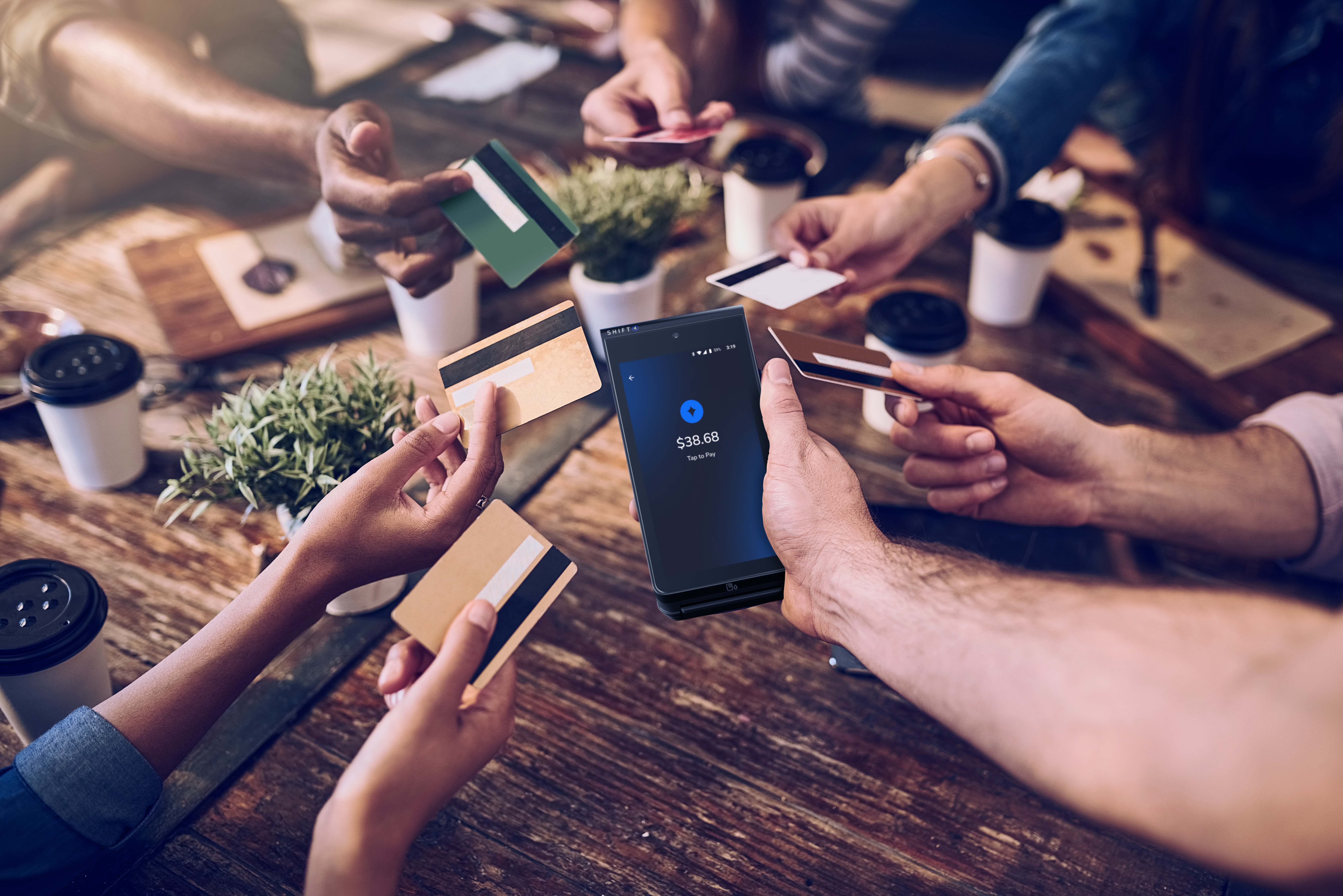 Restaurant customers holding out their credit cards to pay on a SkyTab Mobile POS device - mobile ordering and payments - SkyTab