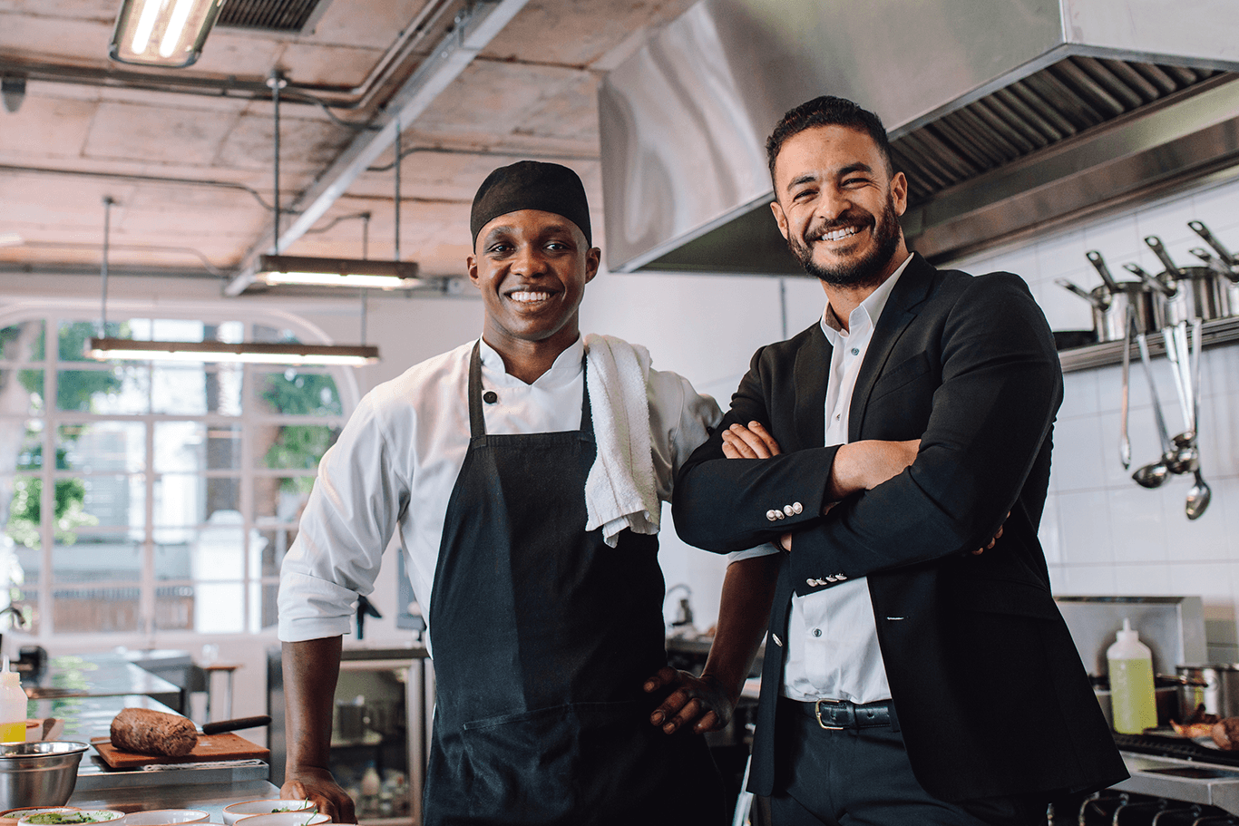 Smiling chef and restaurant owner standing in a kitchen - restaurant types - SkyTab