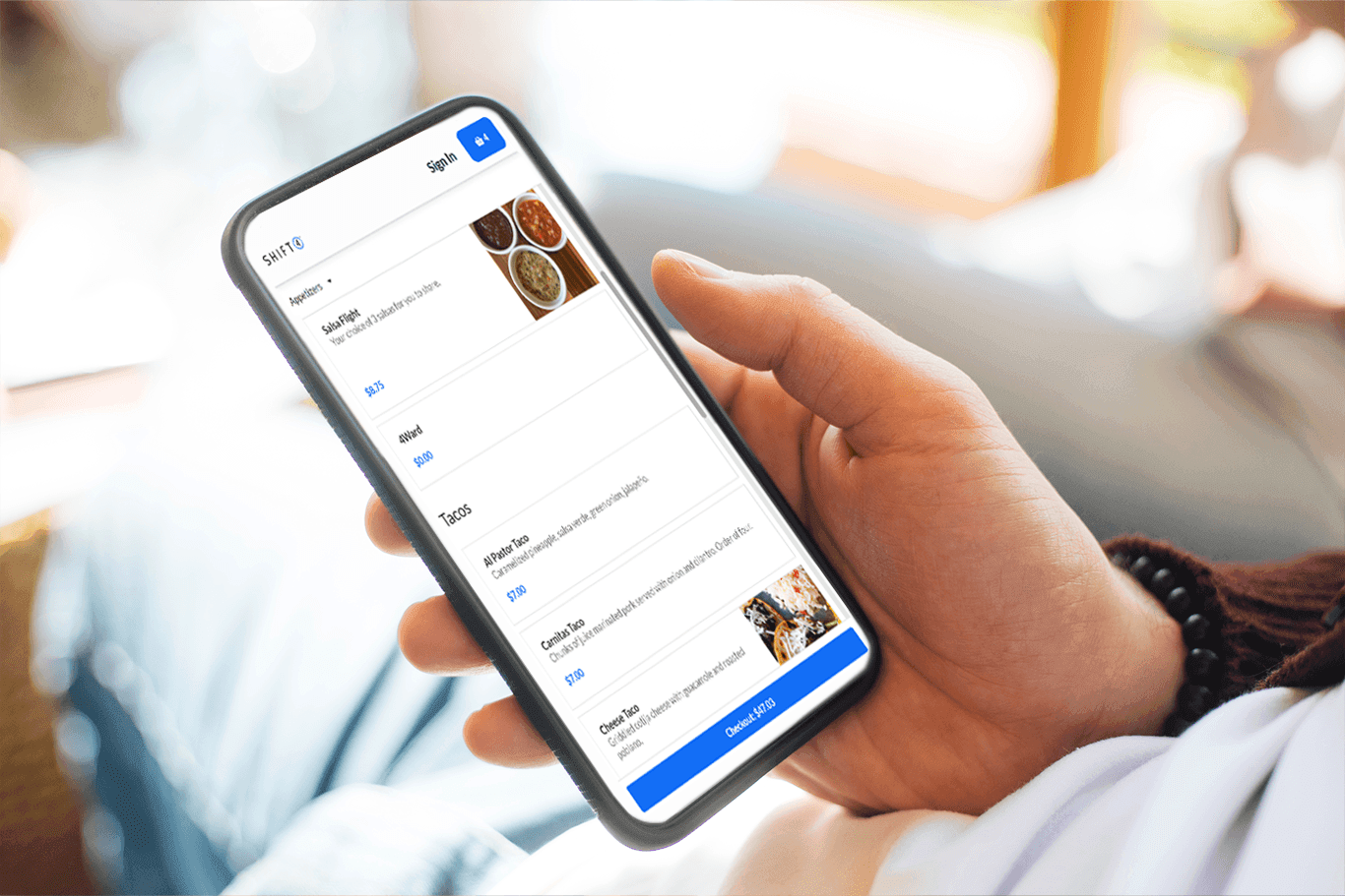 A hand holding a smartphone showing a online ordering menu for a restaurant on the screen - enterprise POS system - SkyTab