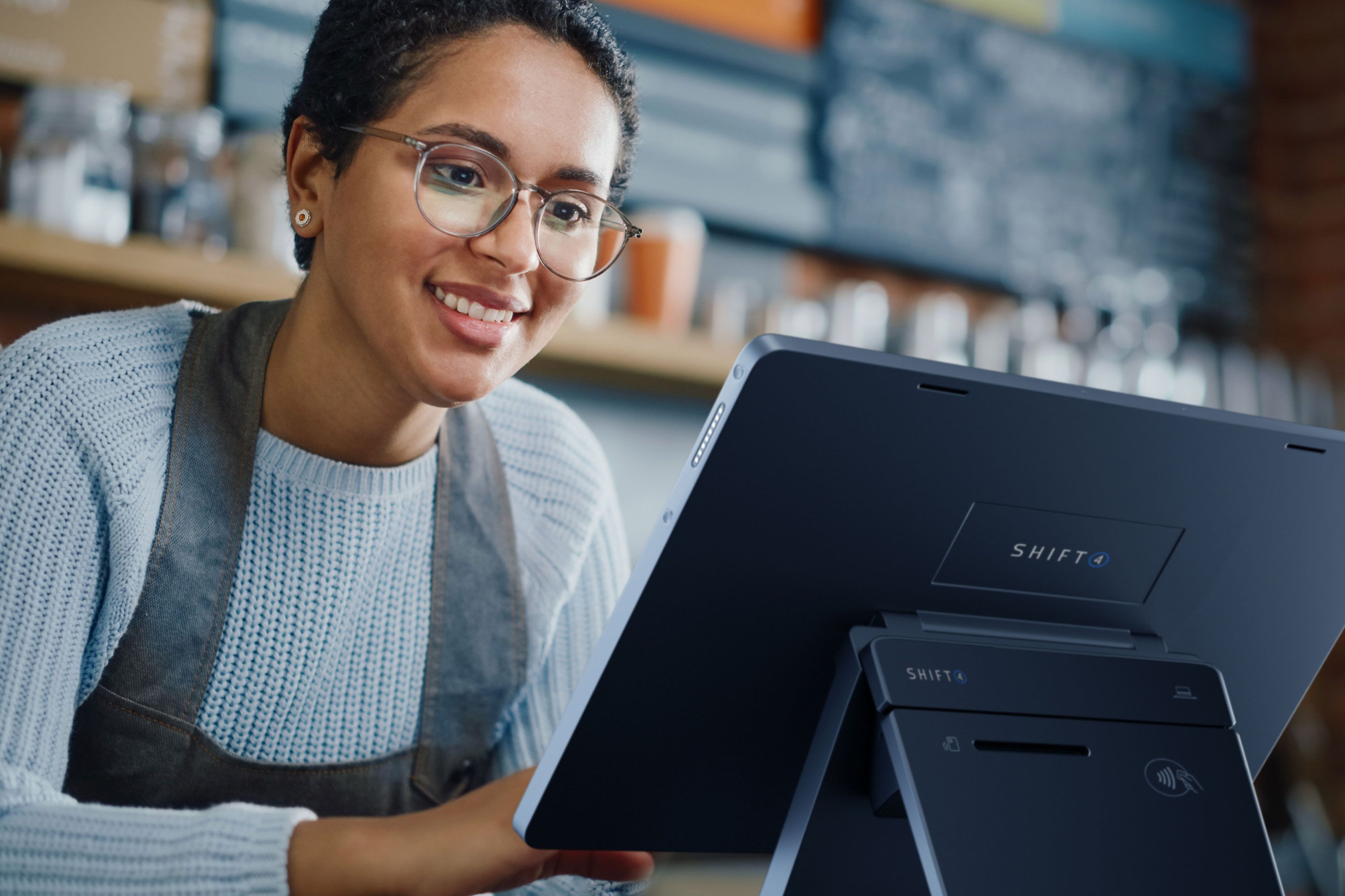 Smiling employee using a Shift4 Dine POS workstation - POS hardware - Shift4 Dine