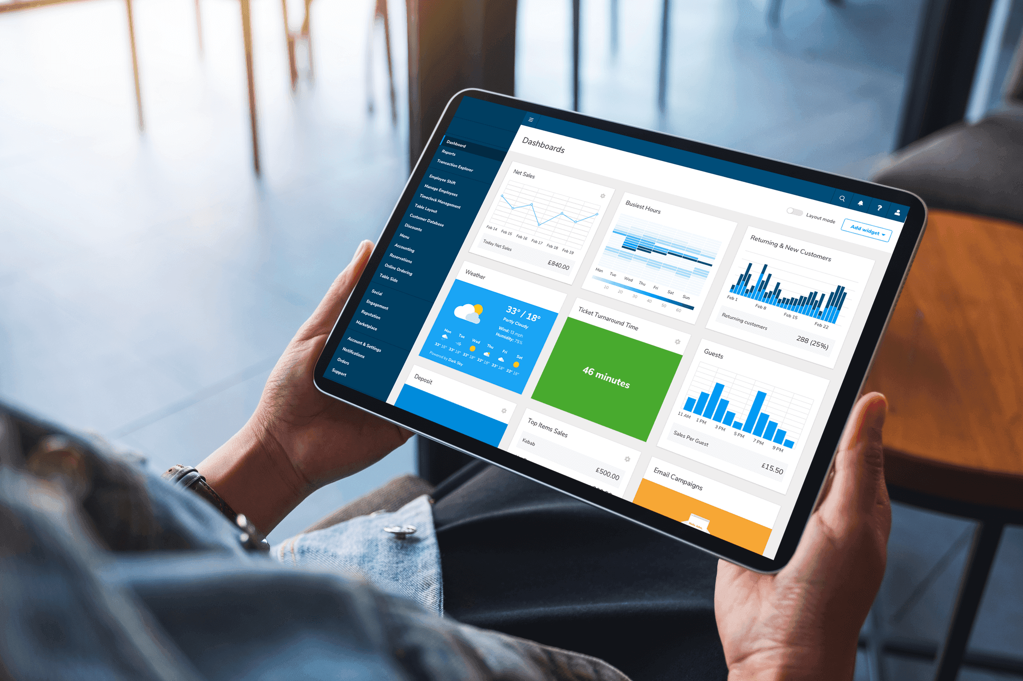 Person holding a tablet showing the Shift4 Dine Customer Hub dashboard - POS features - Shift4 Dine