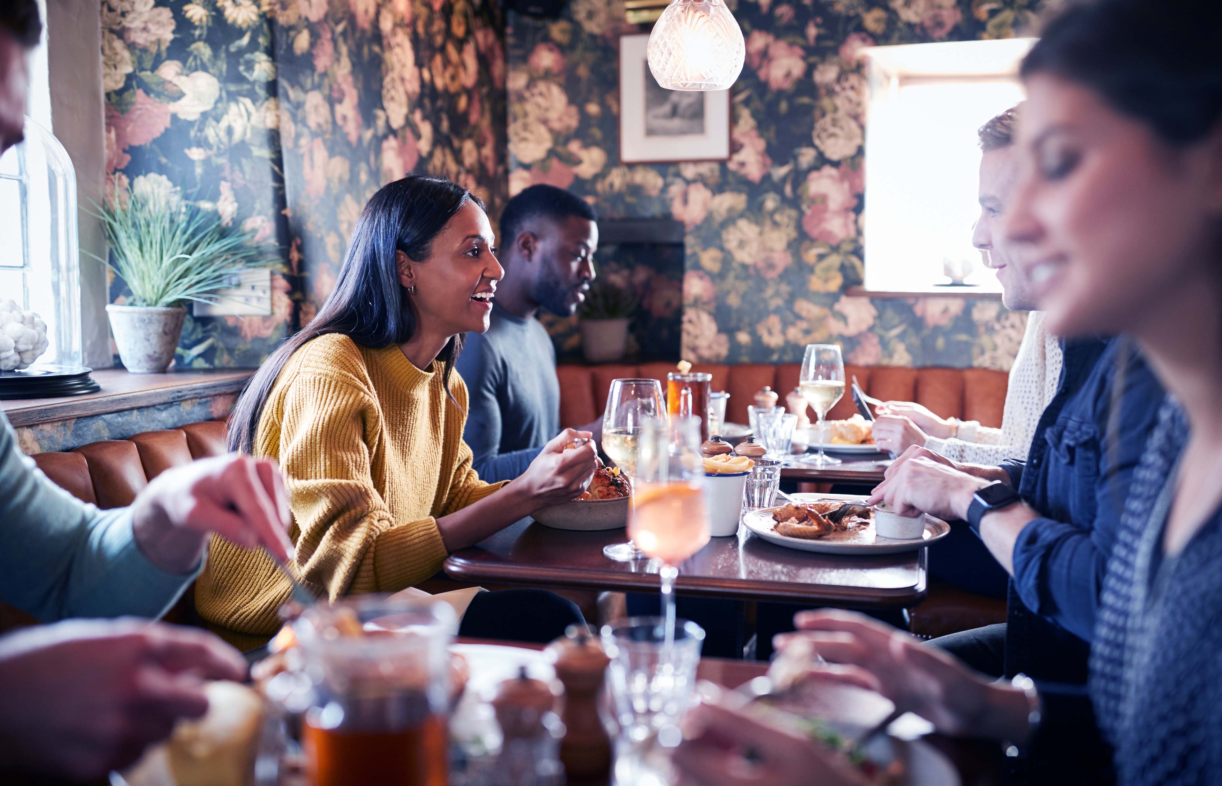 Restaurant customers talking and eating at tables - reservations and waitlist - Shift4 Dine